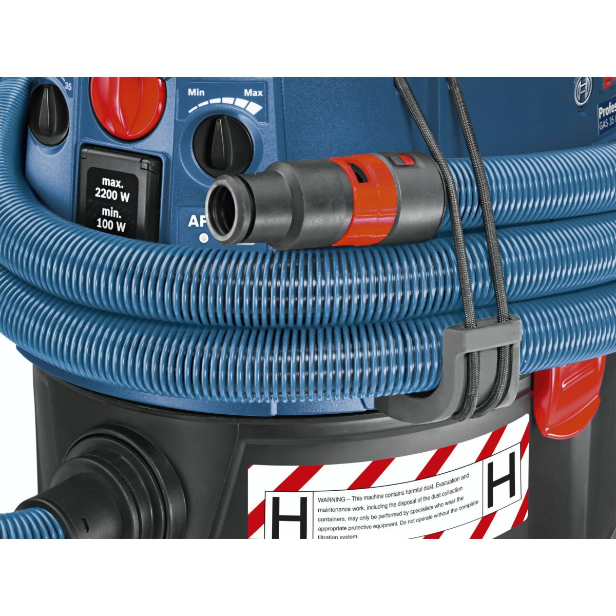 Un aspirapolvere industriale blu e nero con un tubo flessibile ed etichetta di avvertimento.