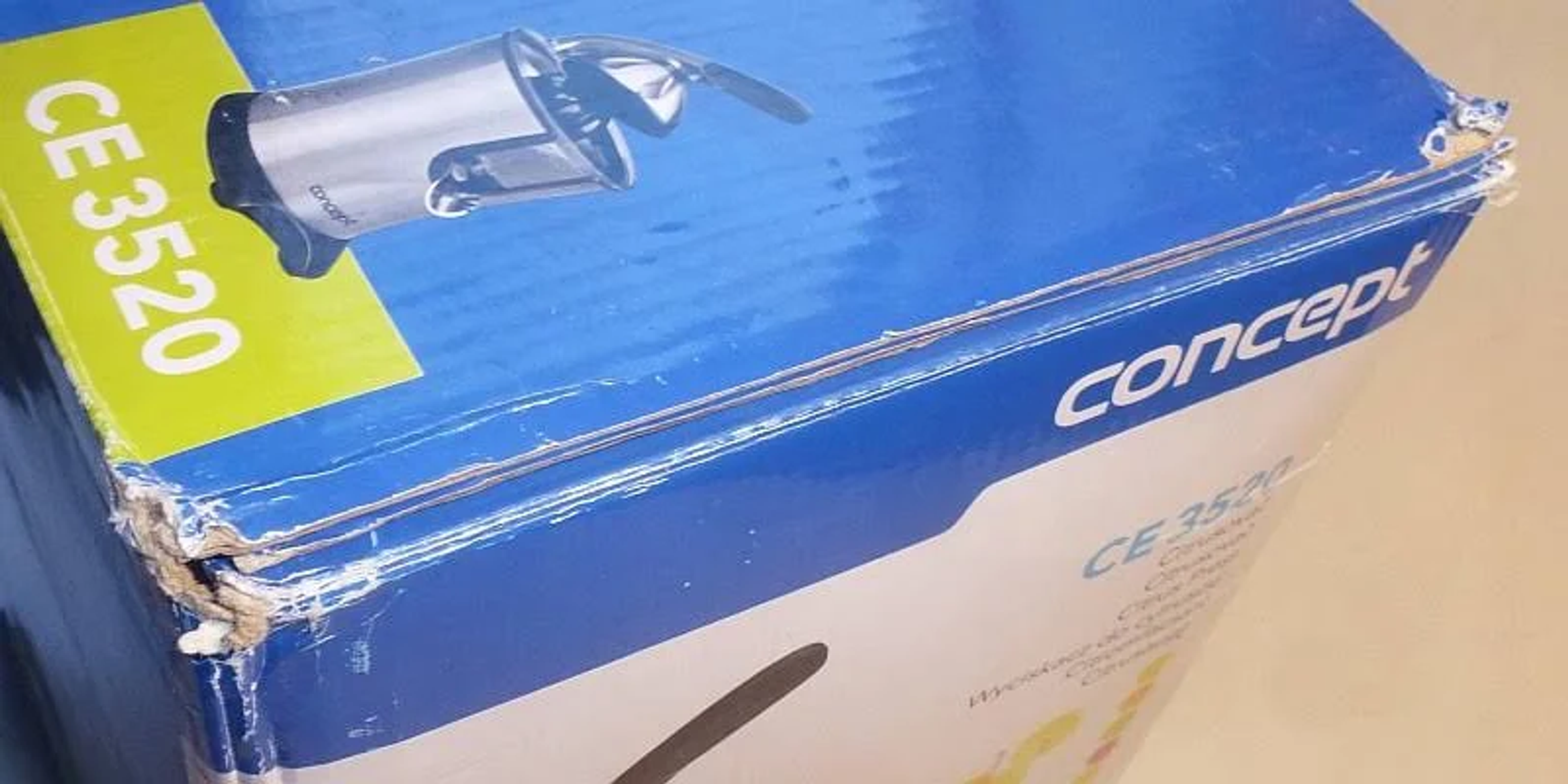 Primer plano de una caja Concept CE 3520. La caja es azul con texto y un gráfico de una exprimidora.