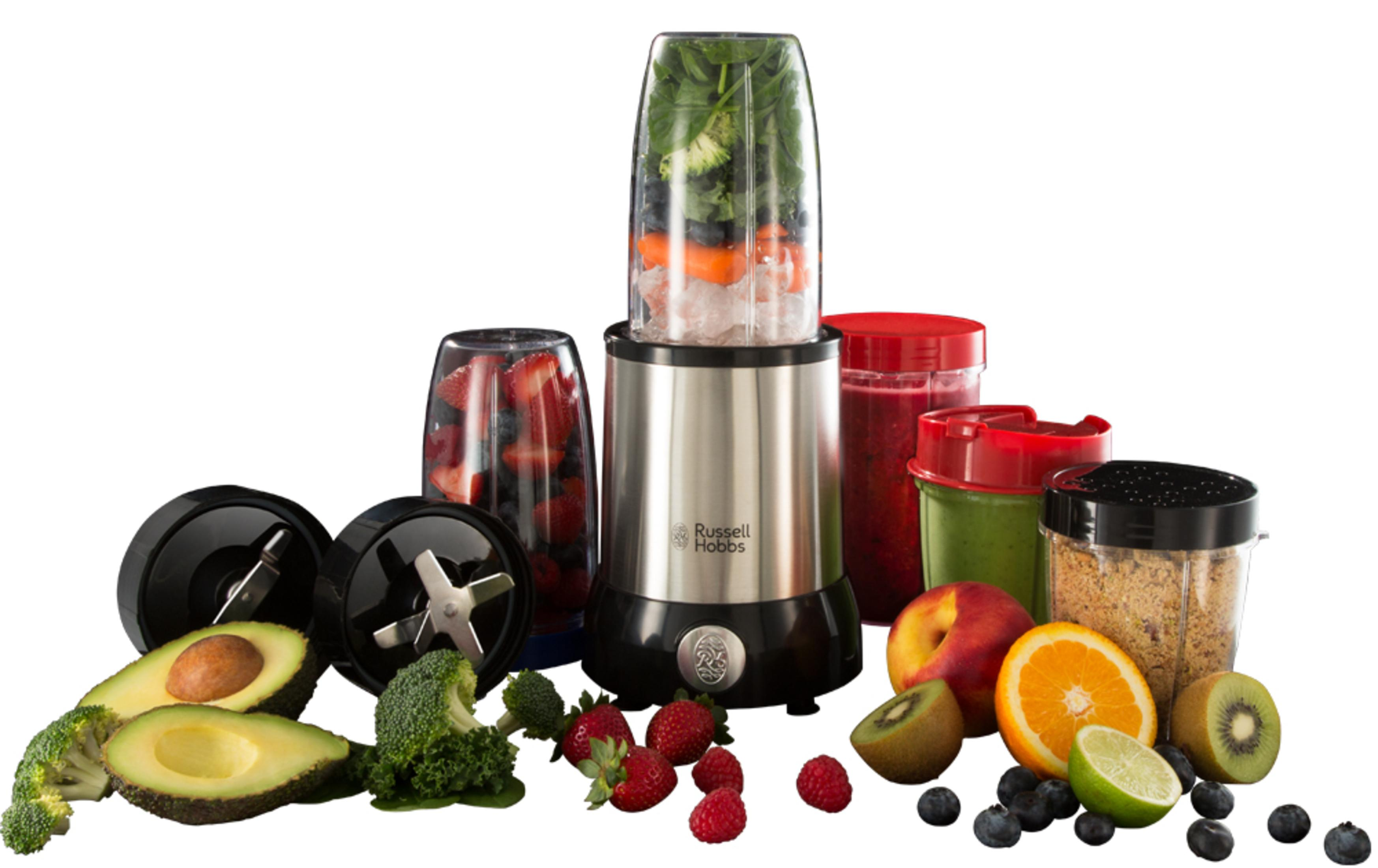 İçinde meyve ve sebzeler bulunan bir blender, etrafında ek kaplar ve malzemeler.
