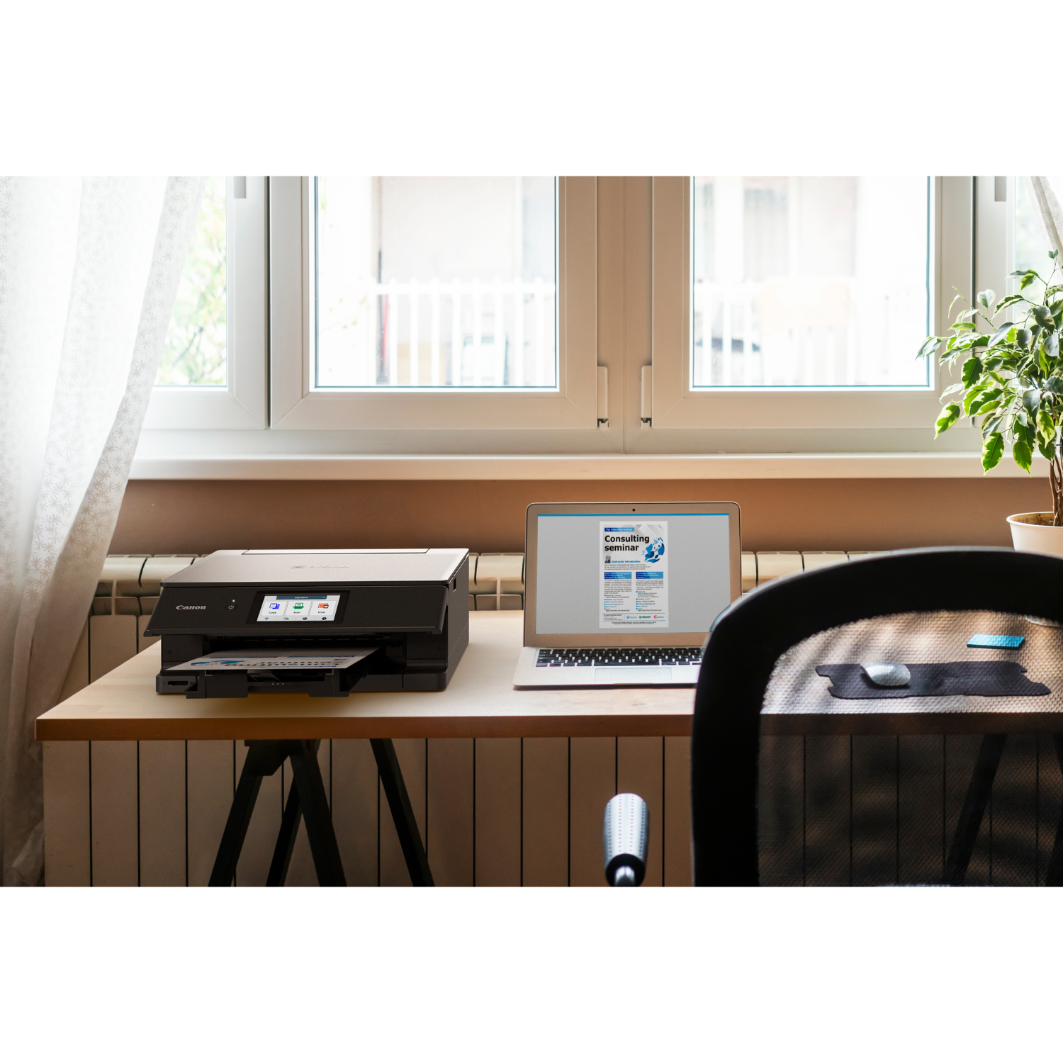 Biurko z drukarką, laptopem wyświetlającym dokument i rośliną.