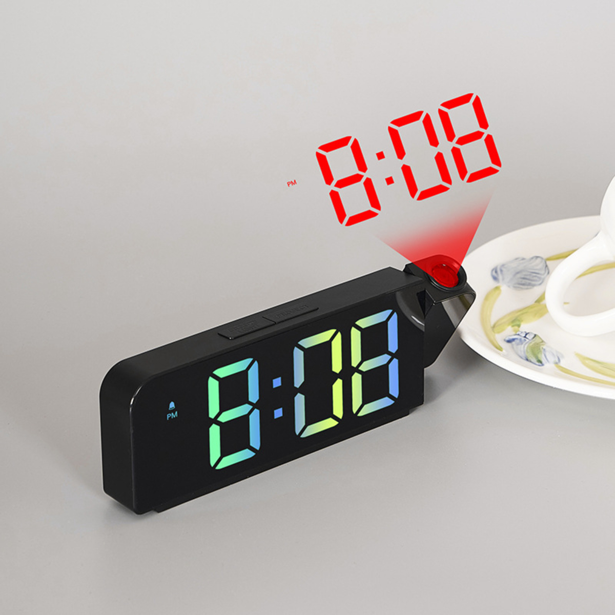Ein schwarzer digitaler Wecker mit grünem Display. Er projiziert die Zeit in Rot.