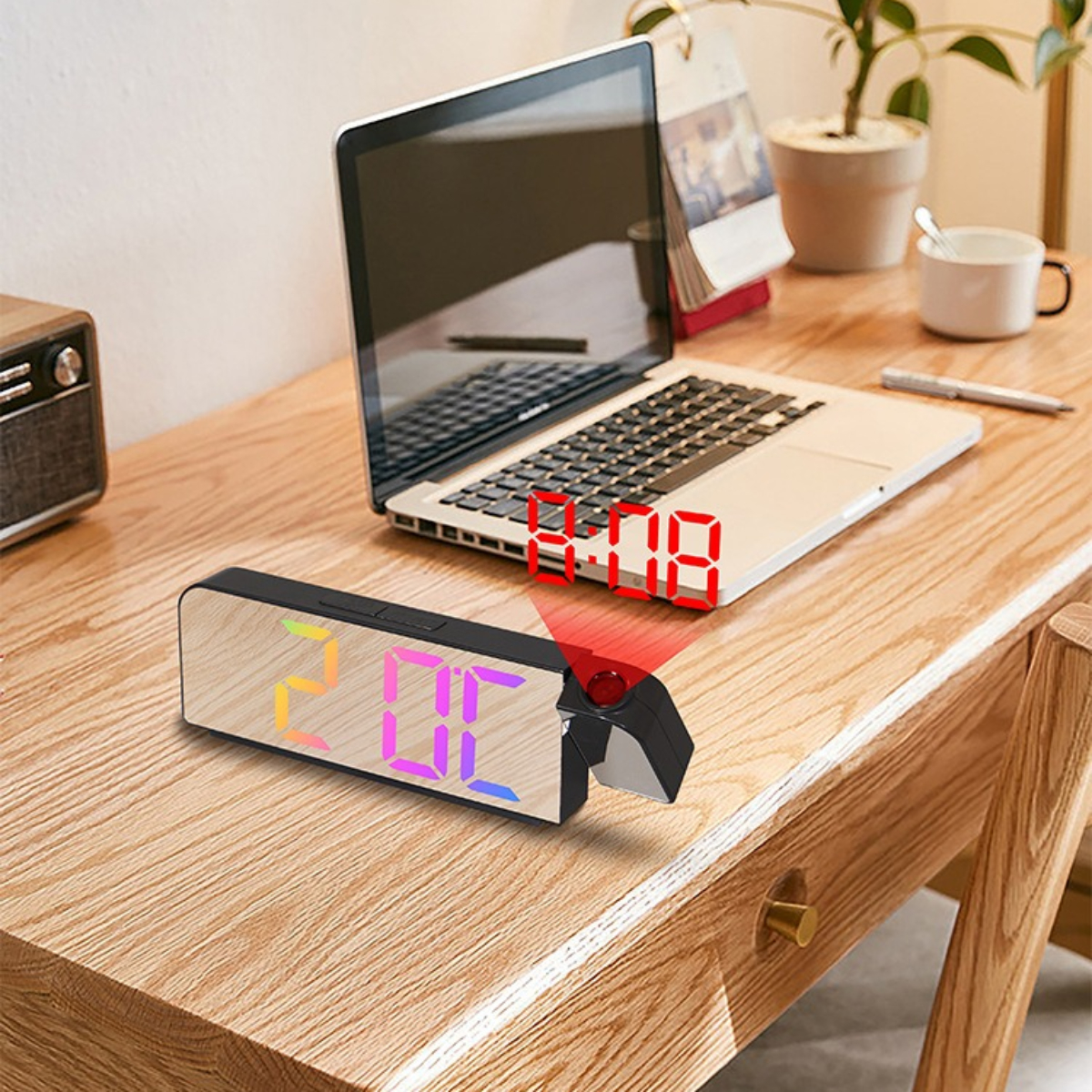 Holzschreibtisch mit Laptop, Uhr, die Zeit projiziert, und kleinem Radio.