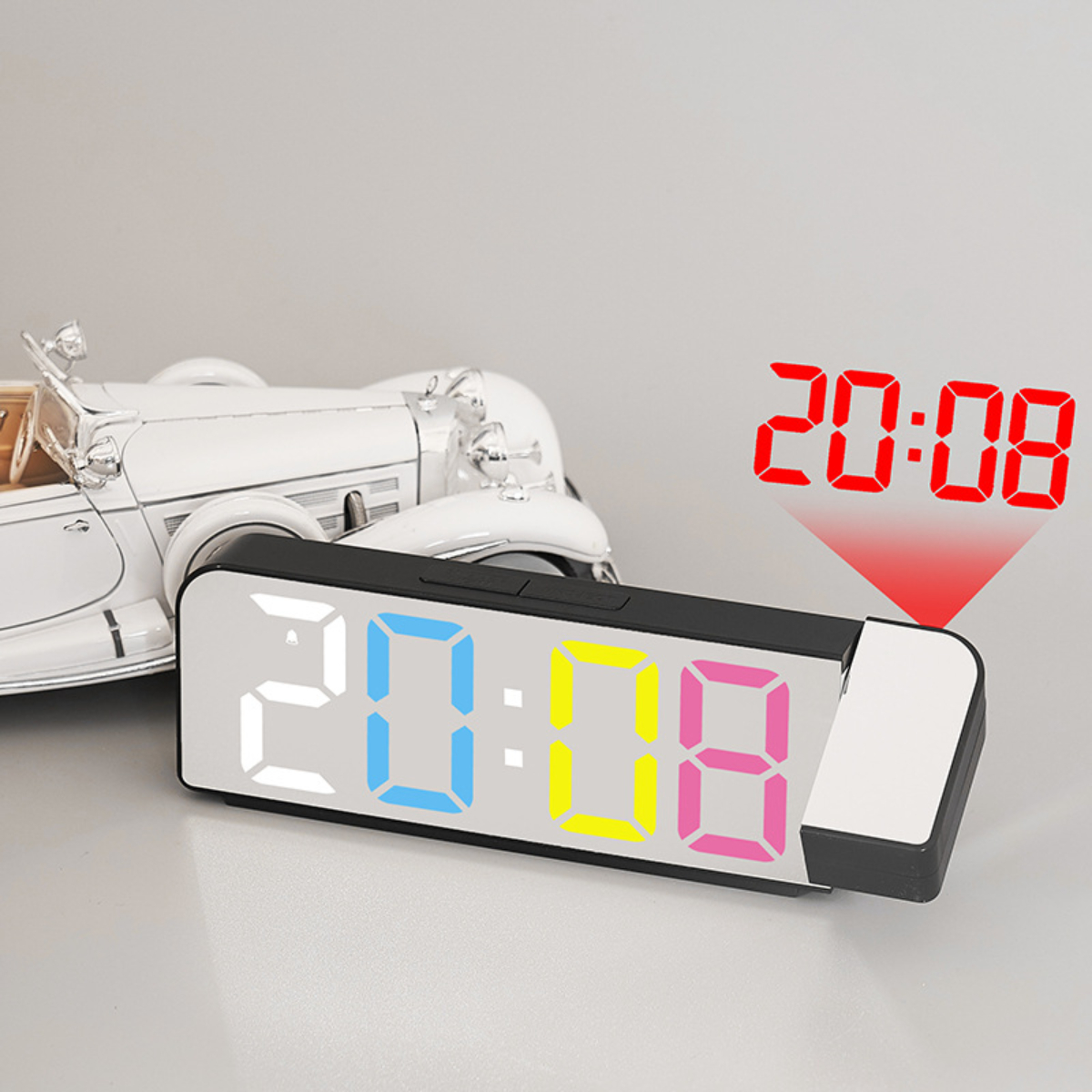 Eine Digitaluhr mit der Anzeige 20:08. Die Uhr hat eine Projektionsfunktion. Hintergrund ist weiß.