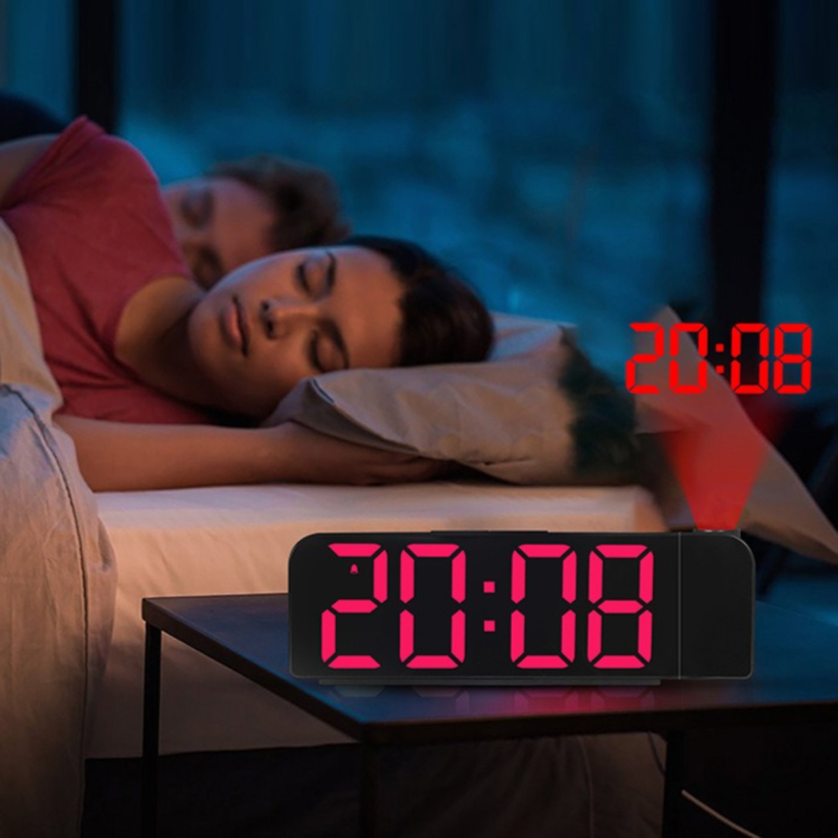 Wecker zeigt 20:08. Zwei Personen schlafen im Hintergrund. Rote Anzeige.