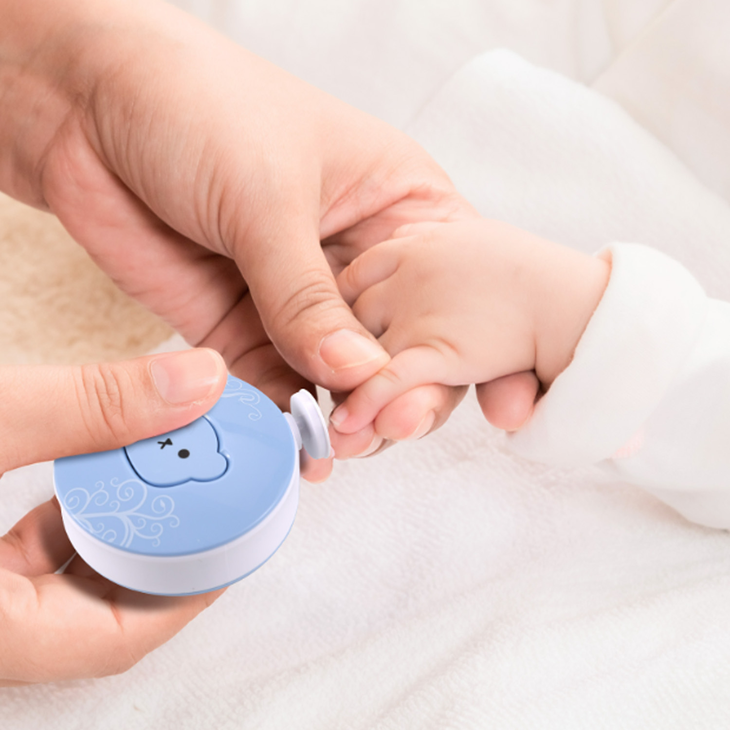 Eine Hand hält die Hand eines Babys mit einem blauen Nagelknipser. Weißer Hintergrund.