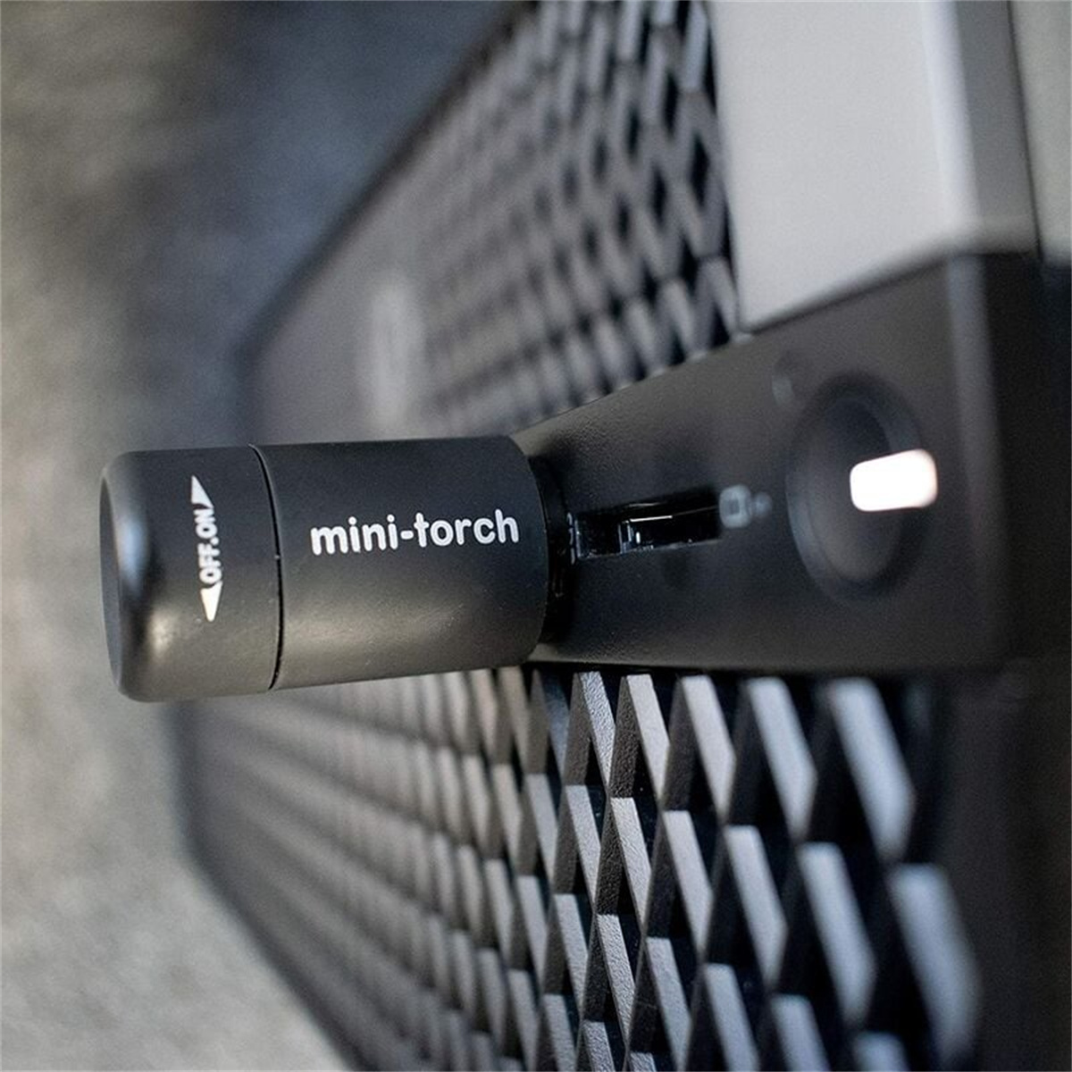 Nahaufnahme einer schwarzen Mini-Taschenlampe mit dem Text 'mini-torch'.