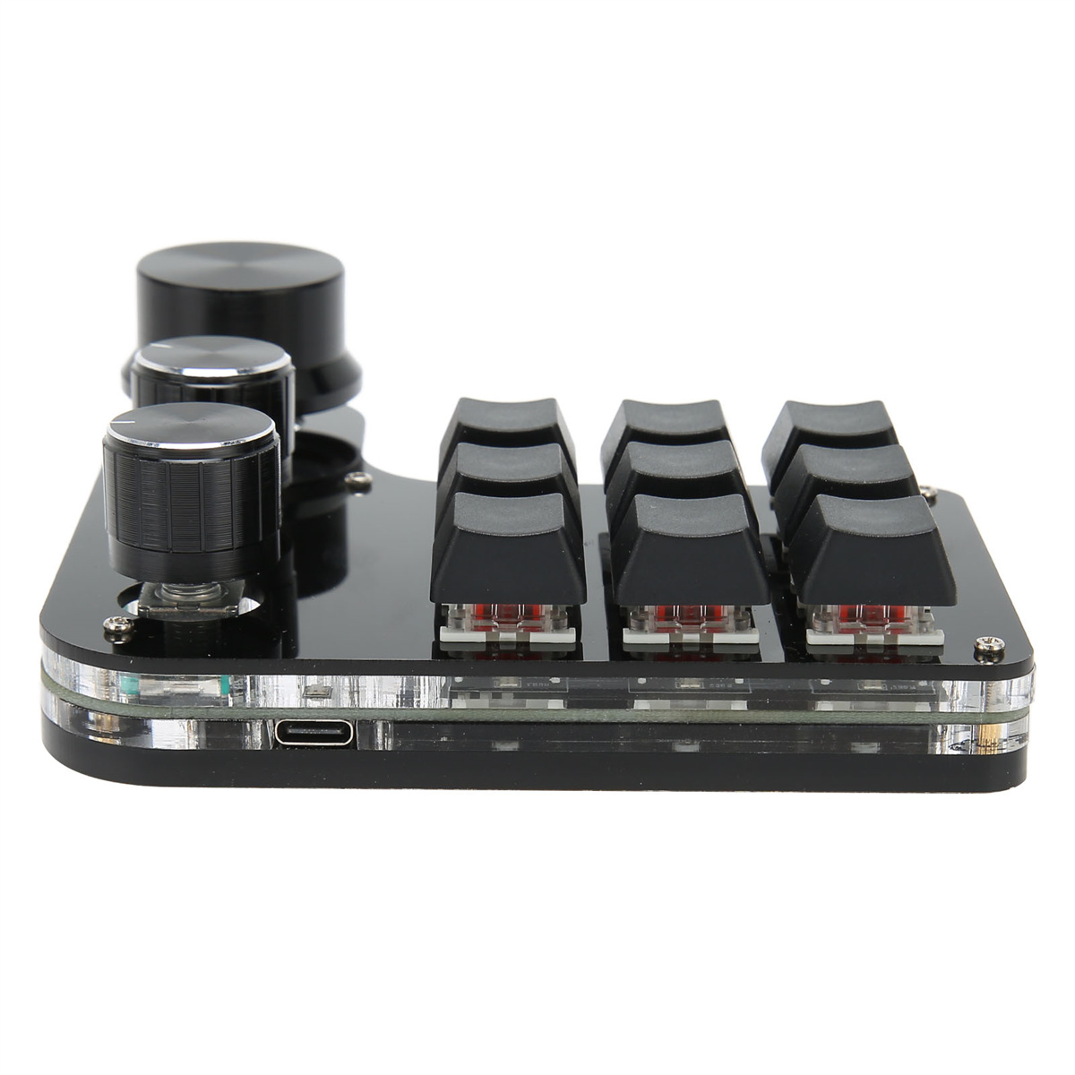 Eine schwarze mechanische Tastatur mit Drehreglern und schwarzen Tasten auf einer weißen Oberfläche.