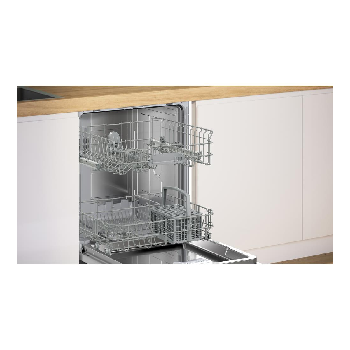 Otwarta zmywarka z dwoma koszami i drewnianym blatem w tle.