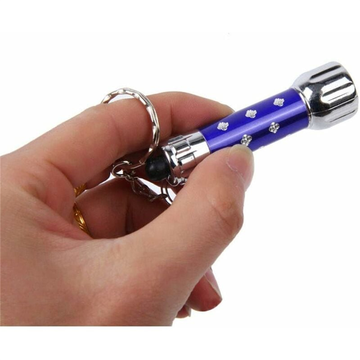Hand hält eine blaue Taschenlampe mit silbernen Details. Schlüsselring befestigt. Weißer Hintergrund.