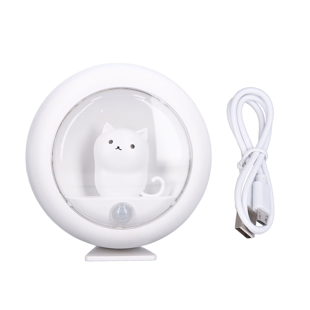 Ein weißes, katzenförmiges Nachtlicht. Ein USB-Kabel liegt daneben. Die Katze befindet sich in einer Glaskugel.