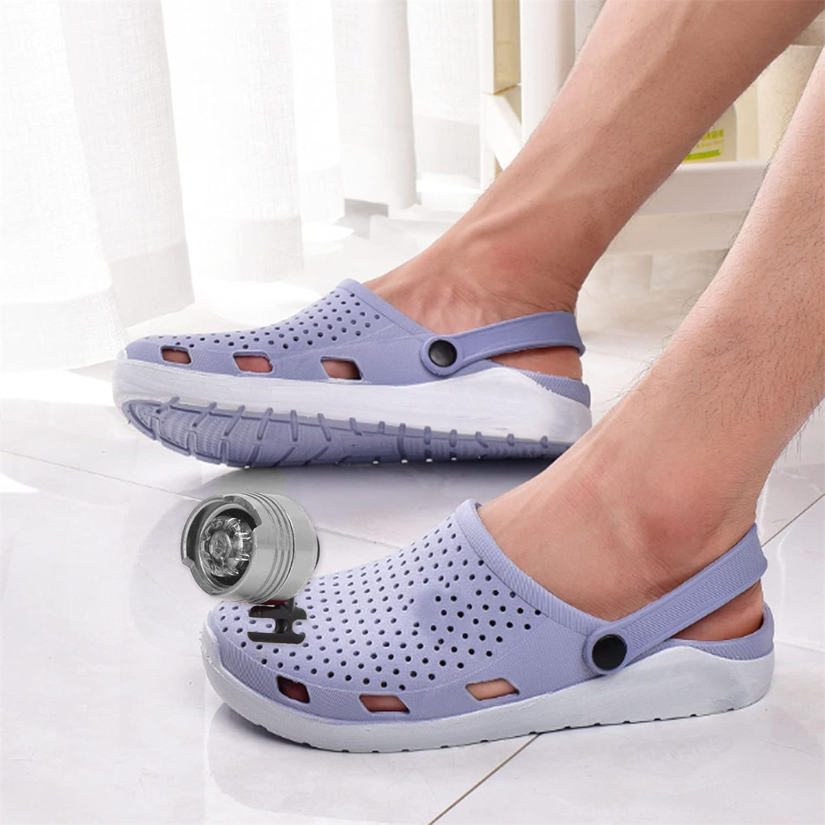 Zwei Füße in lila Clogs, einer mit Licht und der andere mit der Sohle.