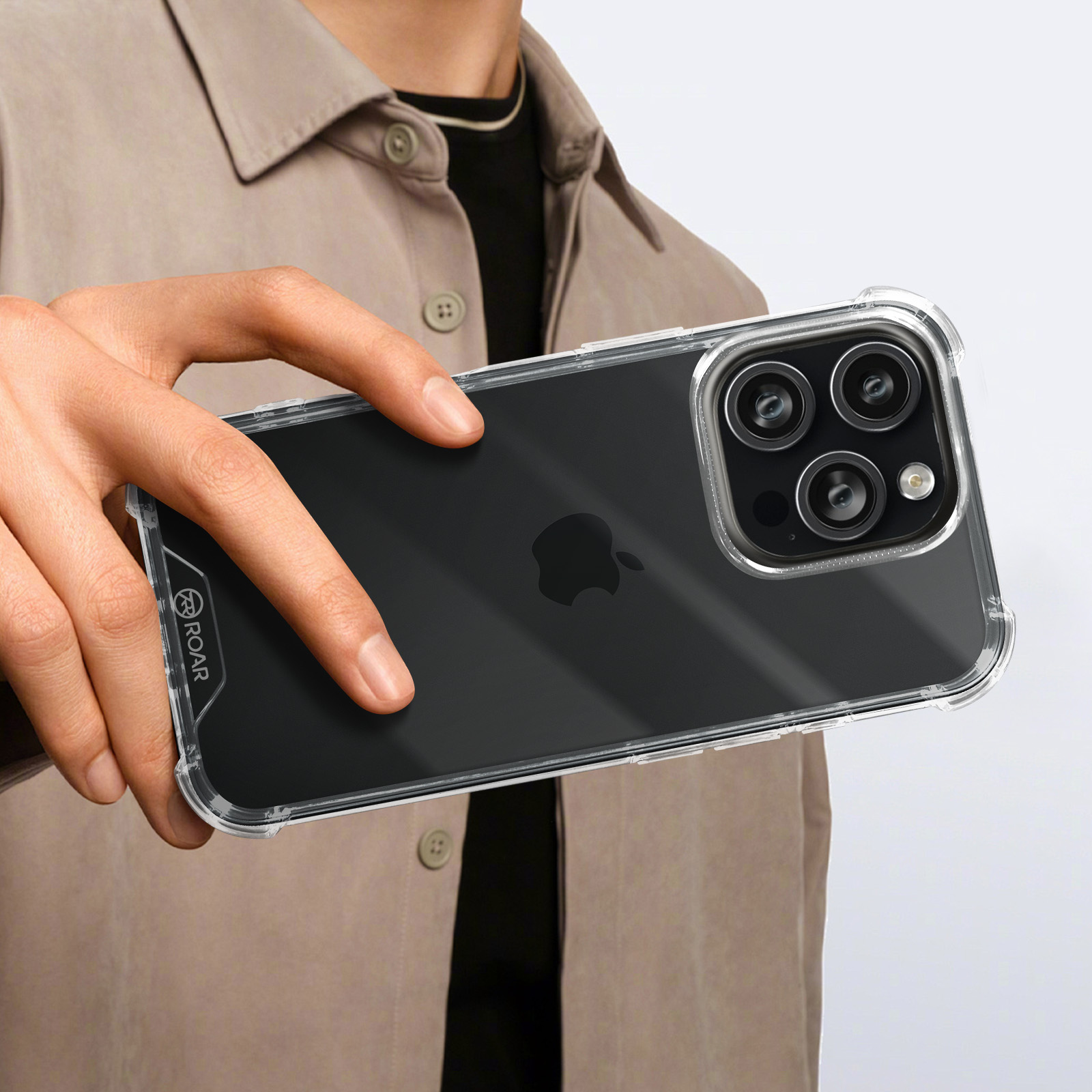 Una persona tiene in mano un iPhone nero in una custodia trasparente. Il telefono ha tre fotocamere.