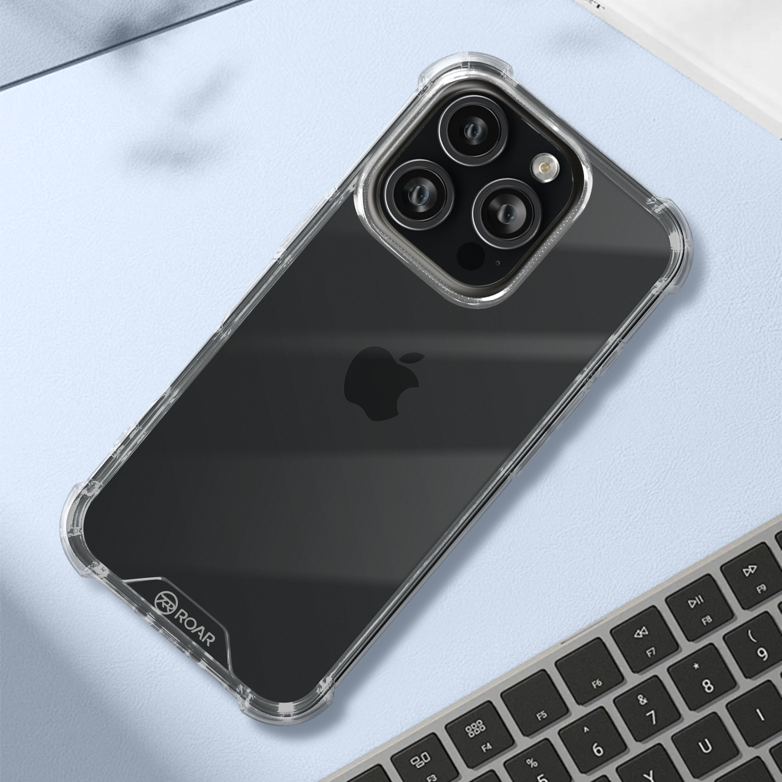 Custodia trasparente per telefono su tastiera con logo Roar. Logo Apple visibile.