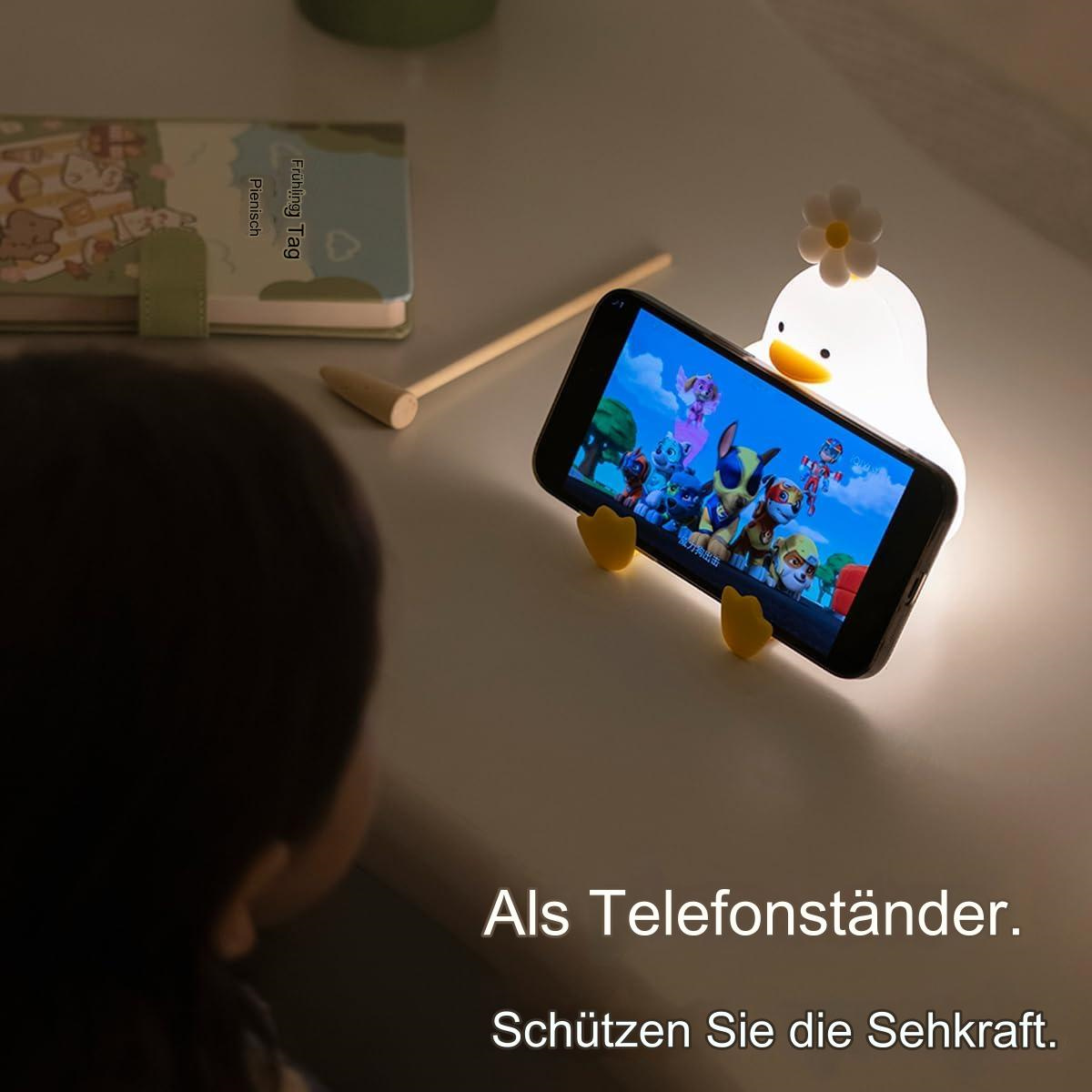 Ein Enten-Nachtlicht, das ein Telefon mit einem Cartoon hält. Text unten.