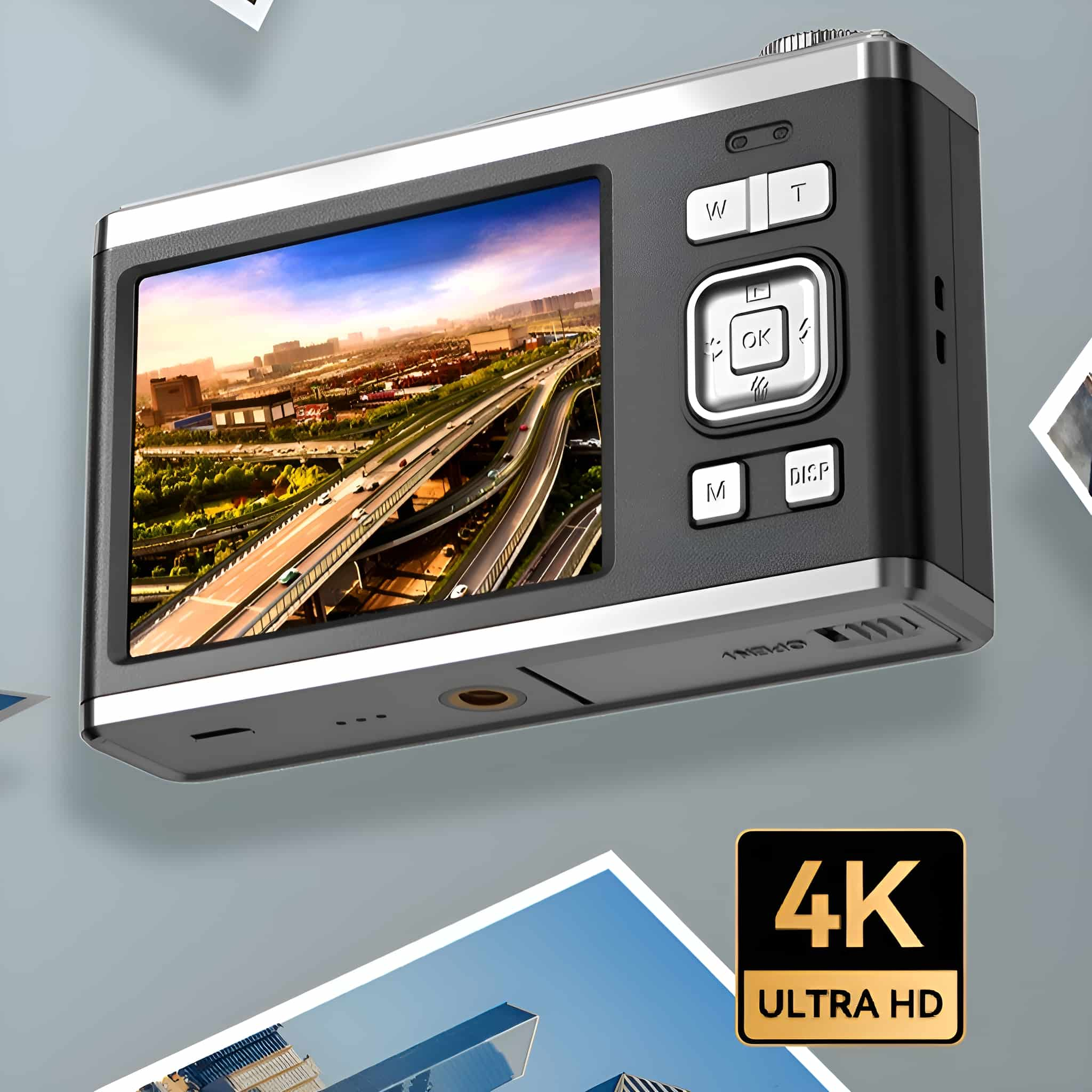 Schwarze und silberne Digitalkamera. Zeigt eine Stadtszene. Tasten: M, DISP, OK, T, W. Text: 4K ULTRA HD.