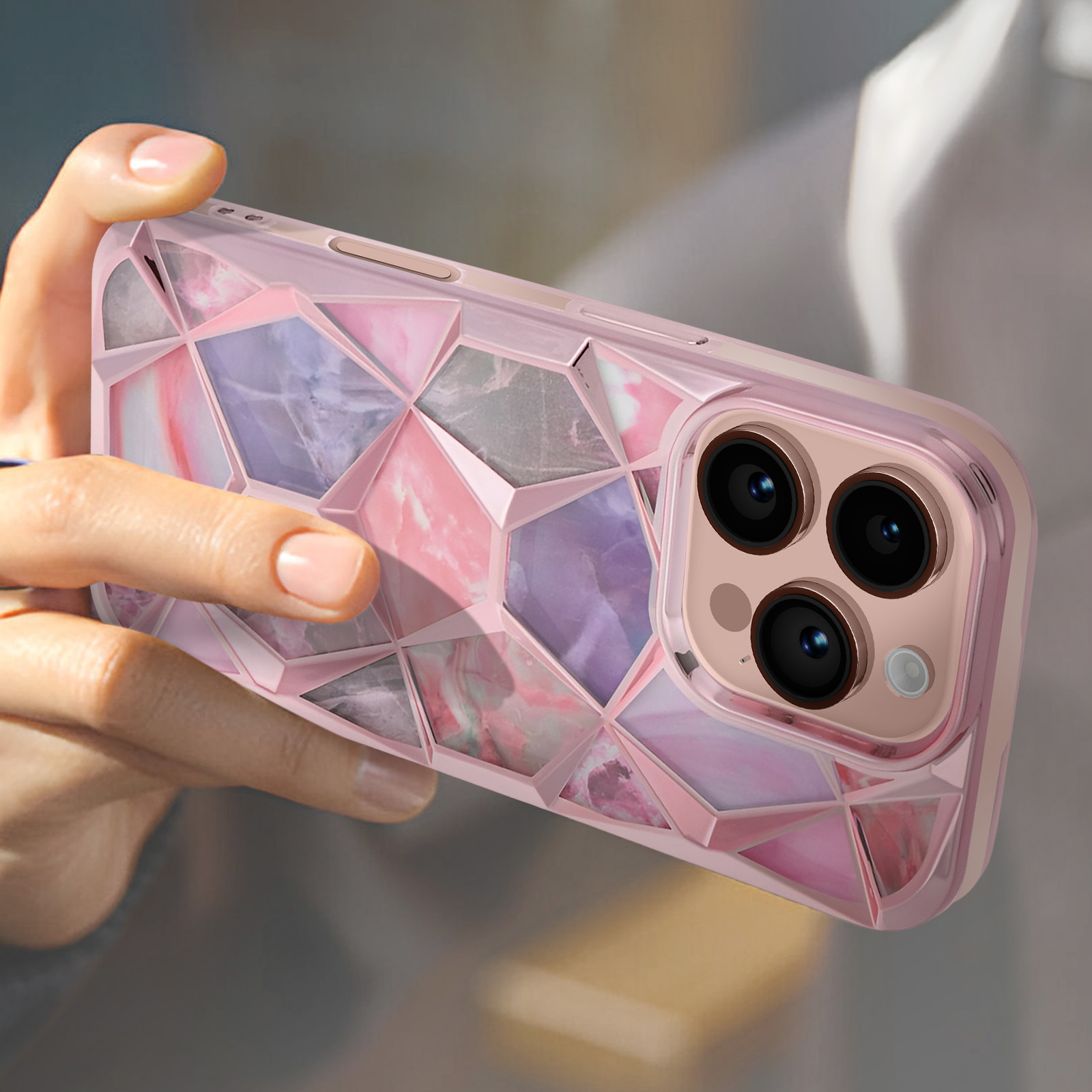 Una custodia geometrica rosa per telefono tenuta in mano. La custodia ha un design marmoreo.