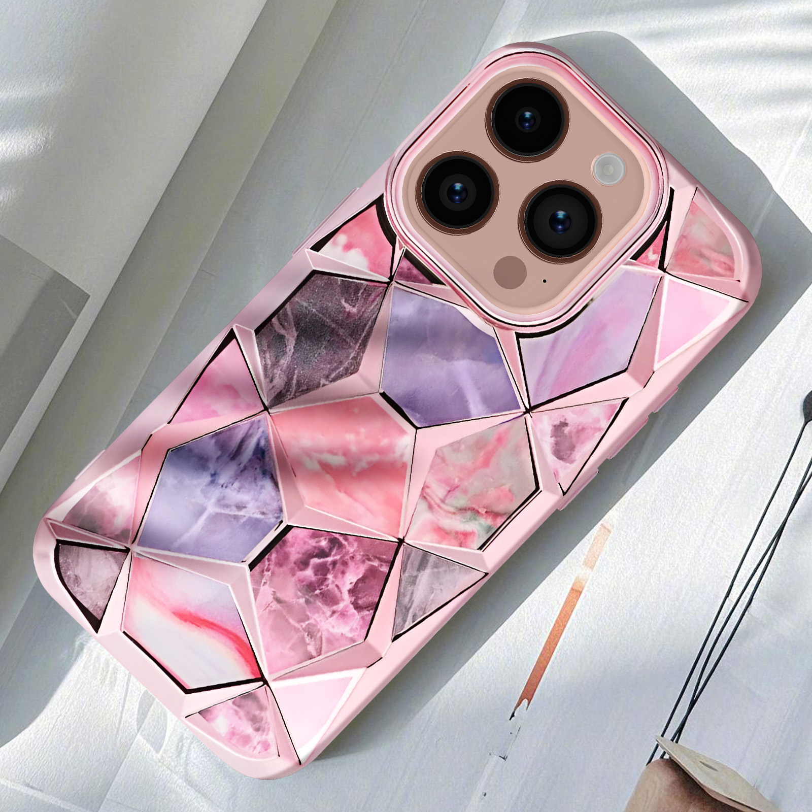 Una custodia per telefono rosa con un motivo geometrico. La custodia è su sfondo bianco.