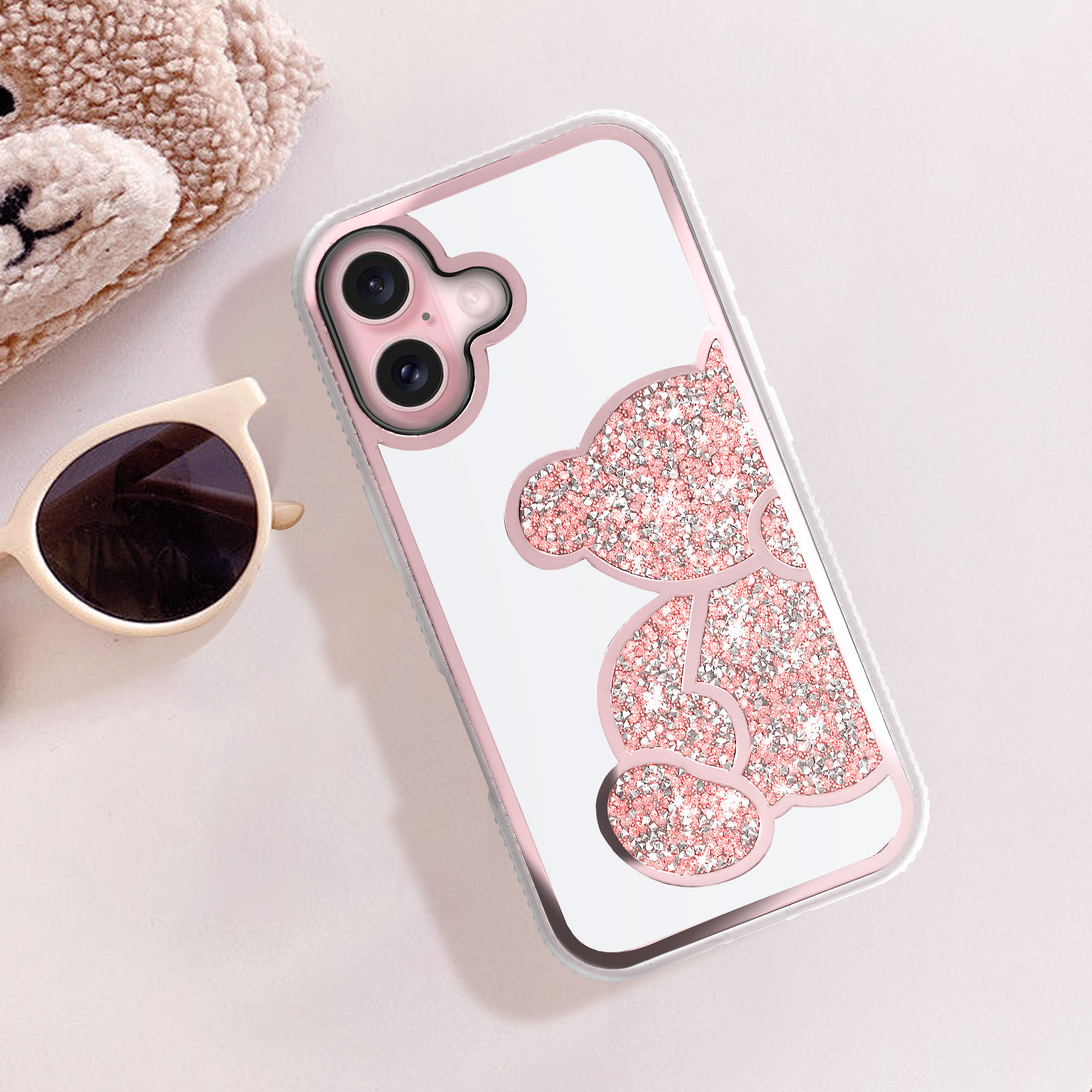 Custodia per telefono rosa con design orsetto glitterato, occhiali da sole e orsacchiotto.
