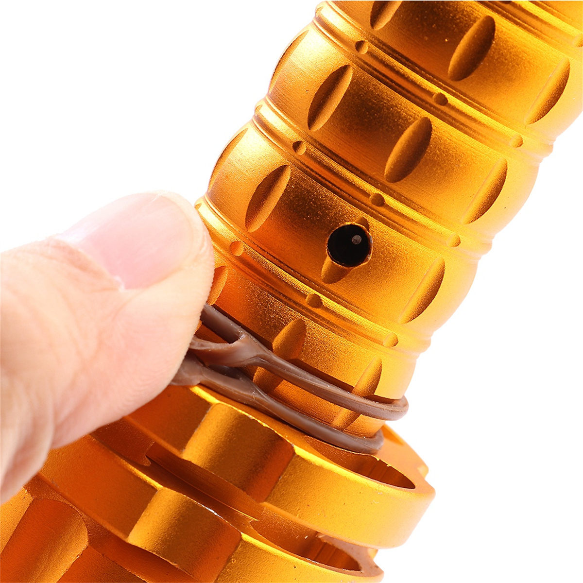 Eine Hand, die das Ende eines goldfarbenen Metallstabs hält.