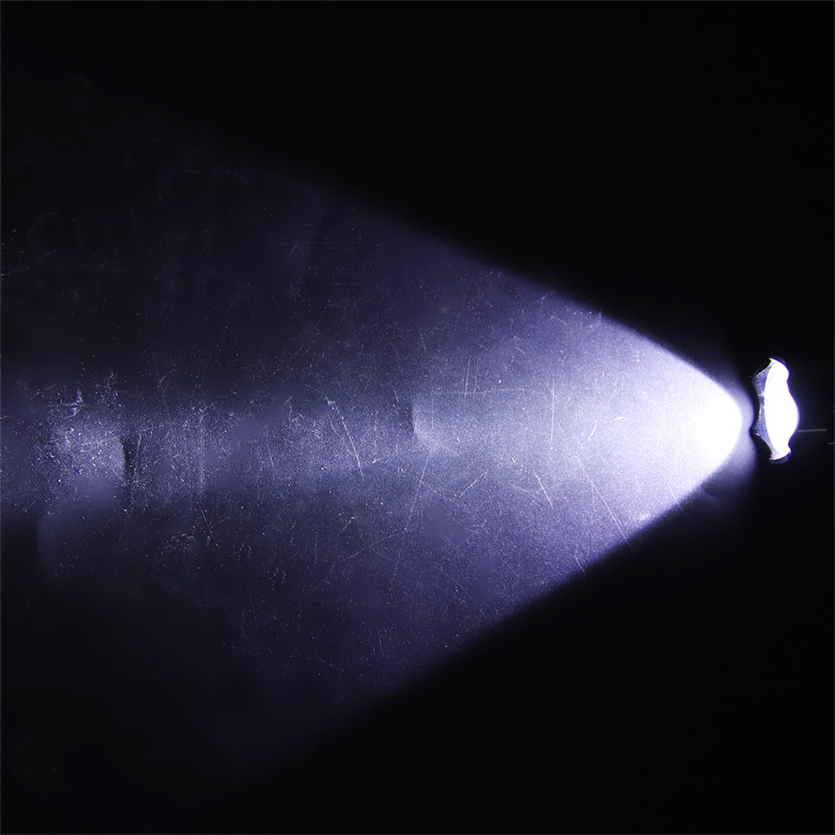 Heller Lichtstrahl, der von einer Quelle ausgeht. Der Hintergrund ist dunkel und strukturiert.