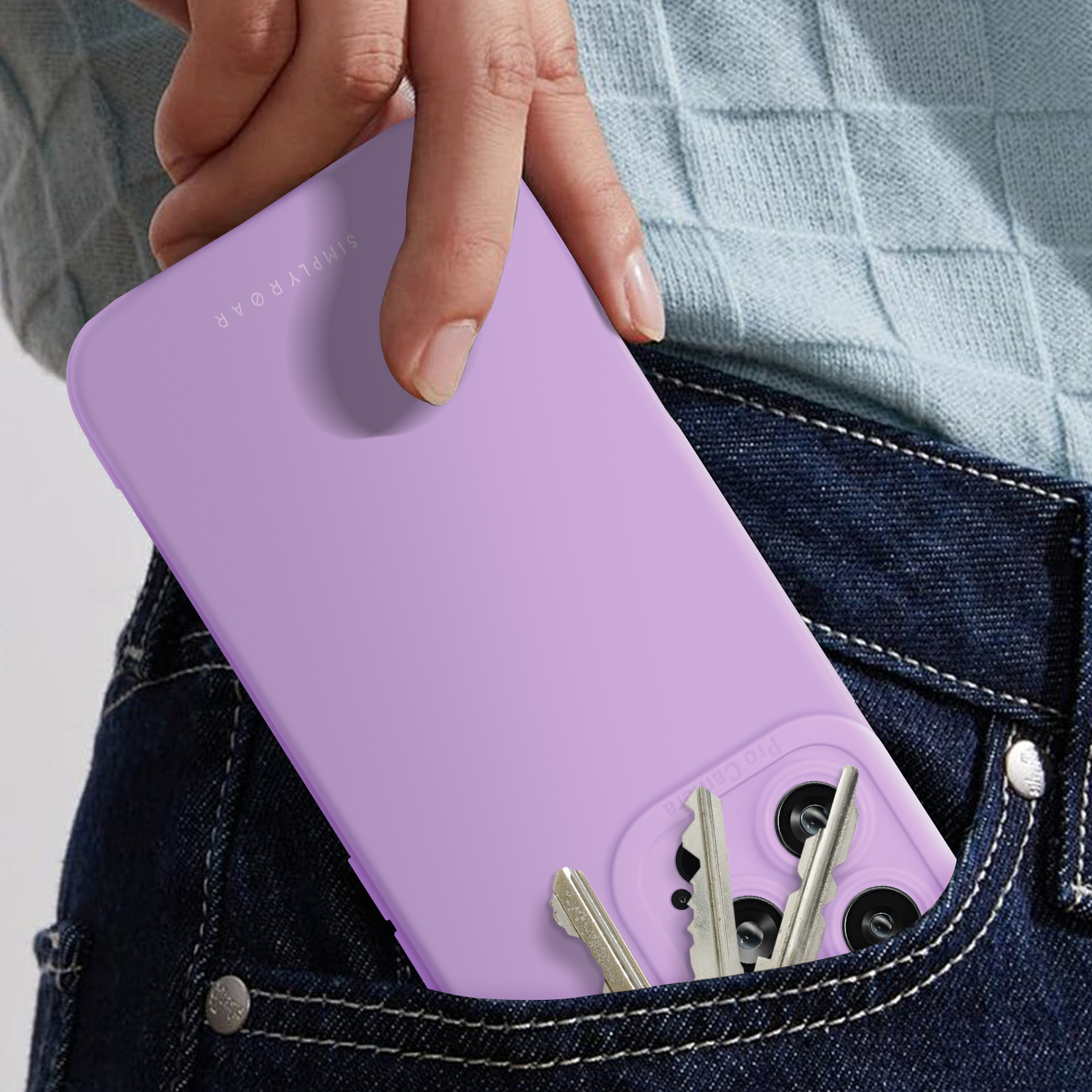 Eine Hand hält ein lila Telefon in einer Jeanshosentasche. Schlüssel sind auch drin.
