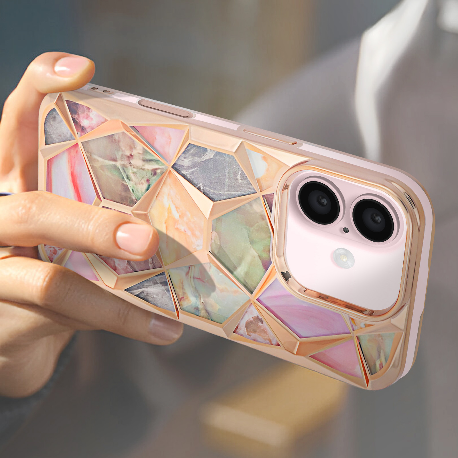 Eine Hand hält ein Telefon mit einem farbenfrohen marmorähnlichen Gehäuse, rosa und goldfarben.