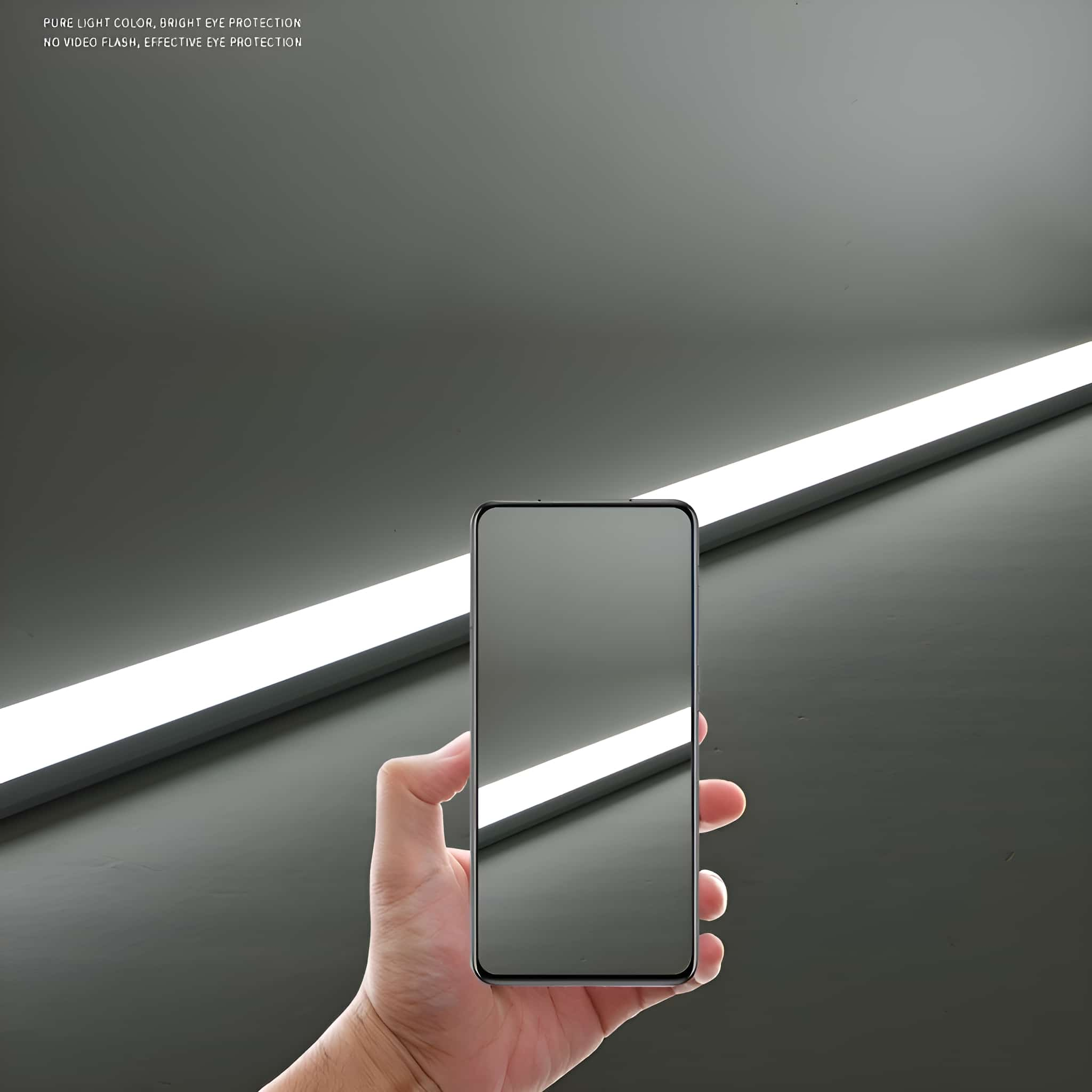 Eine Hand, die ein Telefon neben einer langen, hellen LED-Leuchte hält, mit Text darüber.