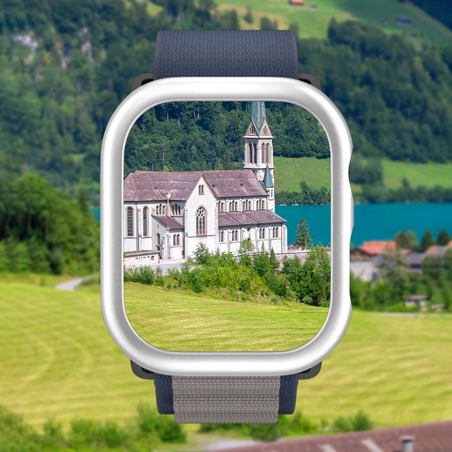 Eine weiße und silberne Apple Watch an einem blauen Armband, mit See und Kirche im Display.