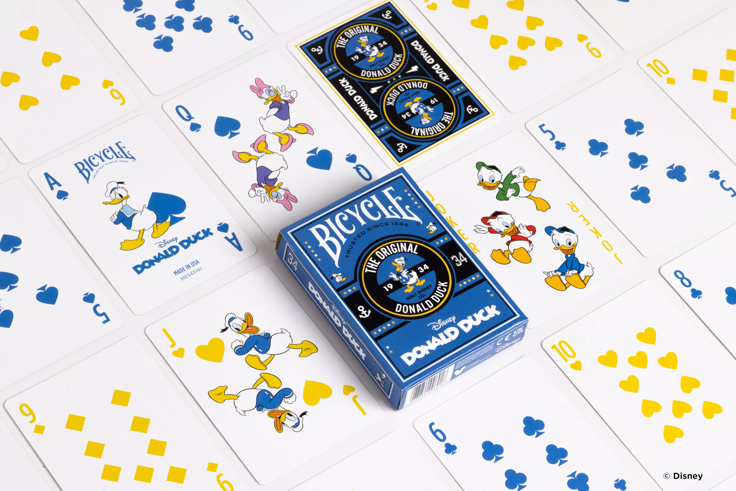 Ein Kartenspiel mit Disney Donald Duck-Spielkarten ist auf einer weißen Oberfläche ausgebreitet.