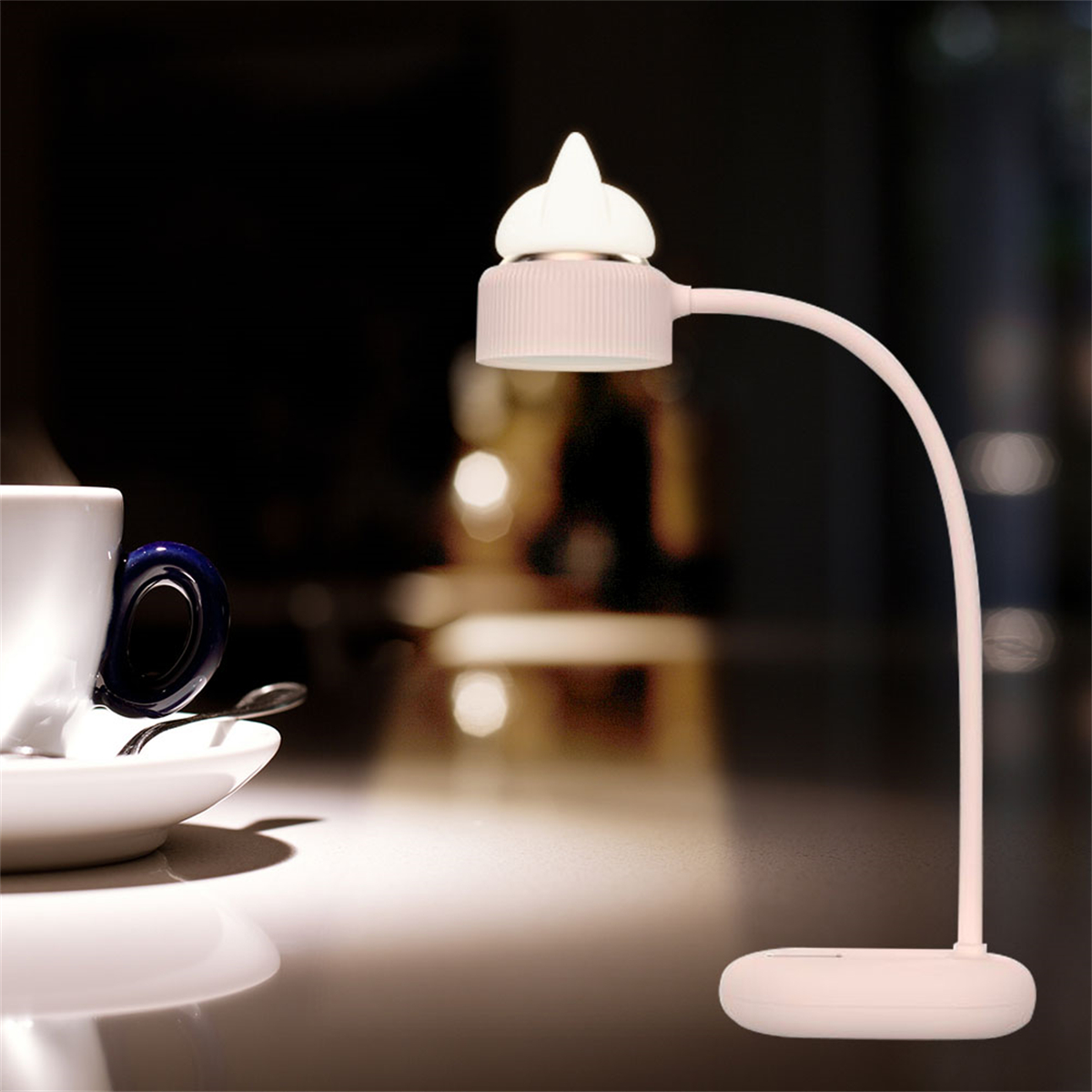Eine kleine Tischlampe mit gebogenem Arm und Glühbirne.