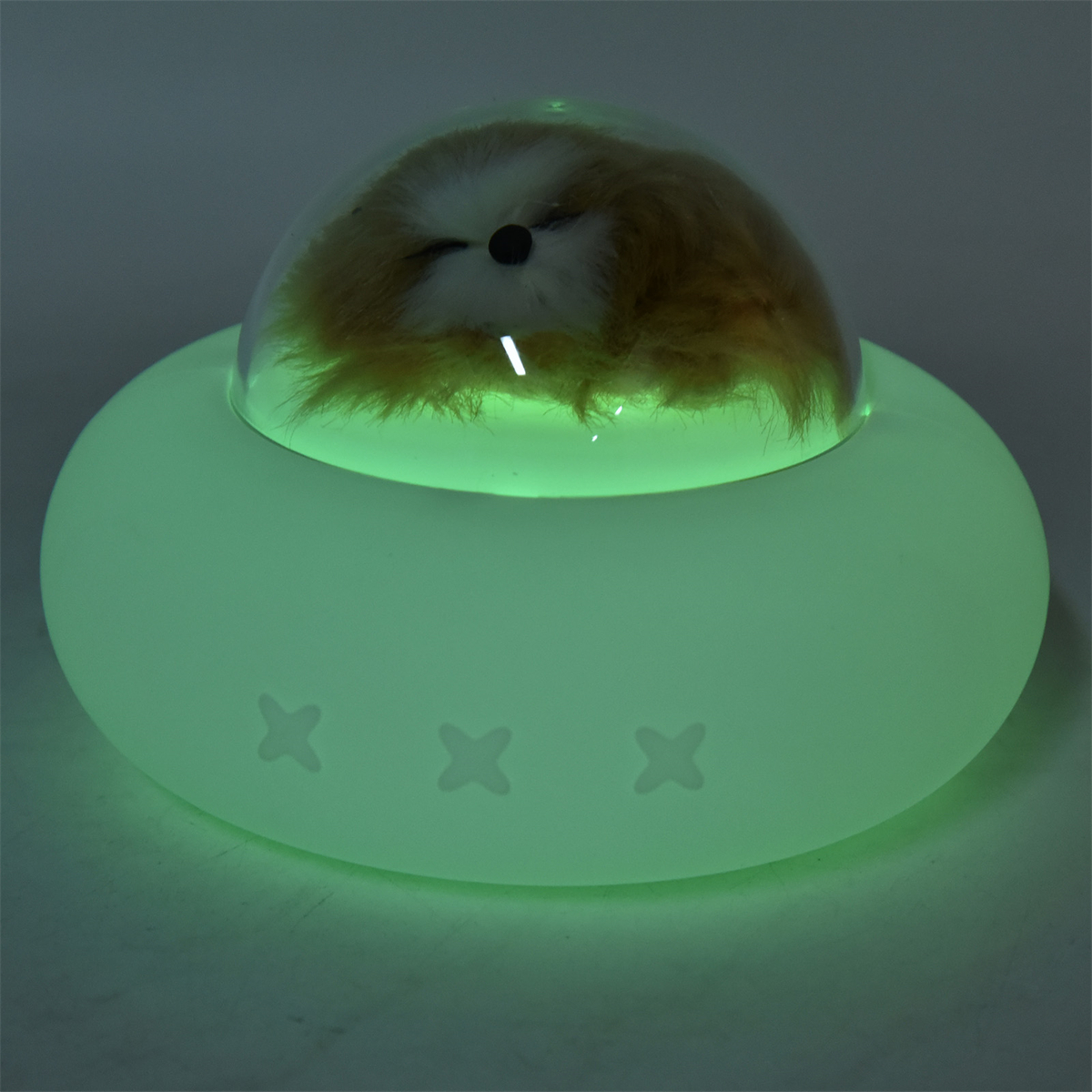 Ein leuchtendes grünes Licht mit einer Faultierfigur im Inneren. Die Lampe hat eine abgerundete Form.