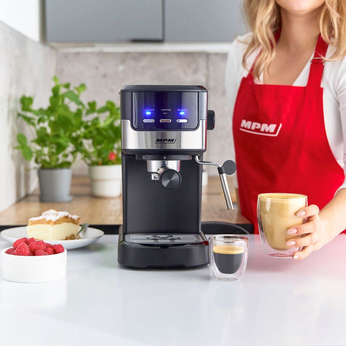 Una donna con un grembiule rosso sta preparando il caffè con una macchina per l'espresso.