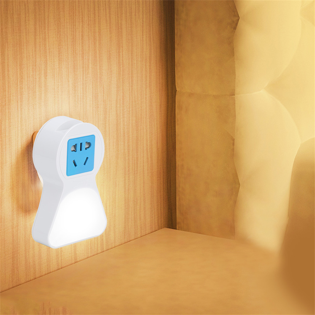 Weißes Nachtlicht mit einer blauen Steckdose, eingesteckt in eine Holzwand. Es sieht aus wie ein kleiner Stecker.