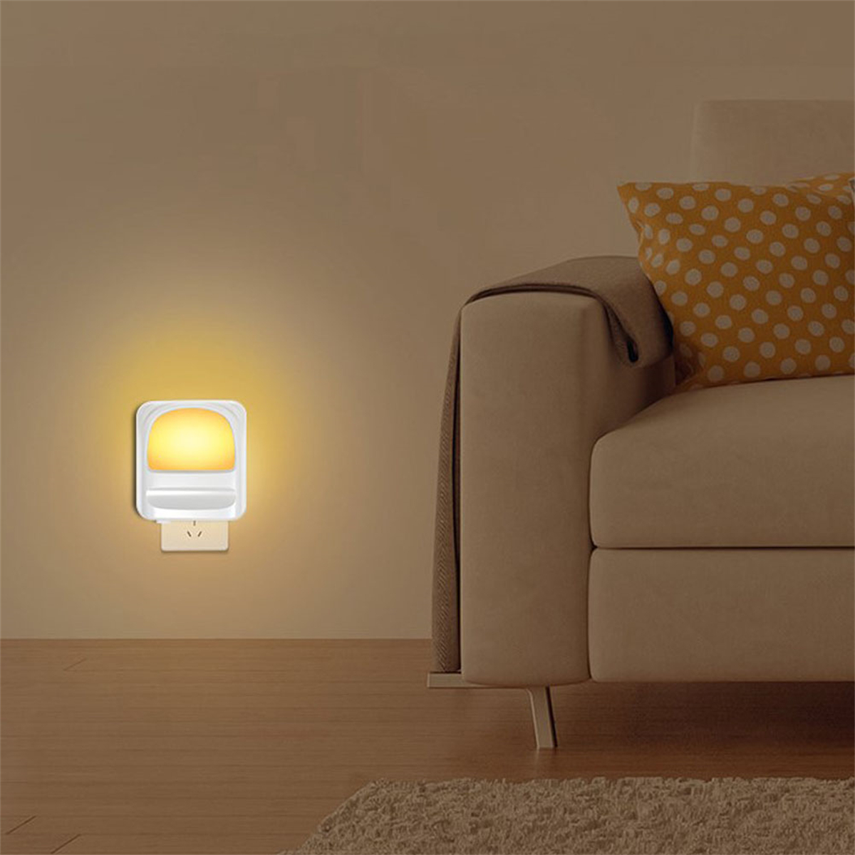 Ein Nachtlicht, das in eine Steckdose neben einem Sofa gesteckt ist. Das Licht gibt ein sanftes gelbes Leuchten ab.