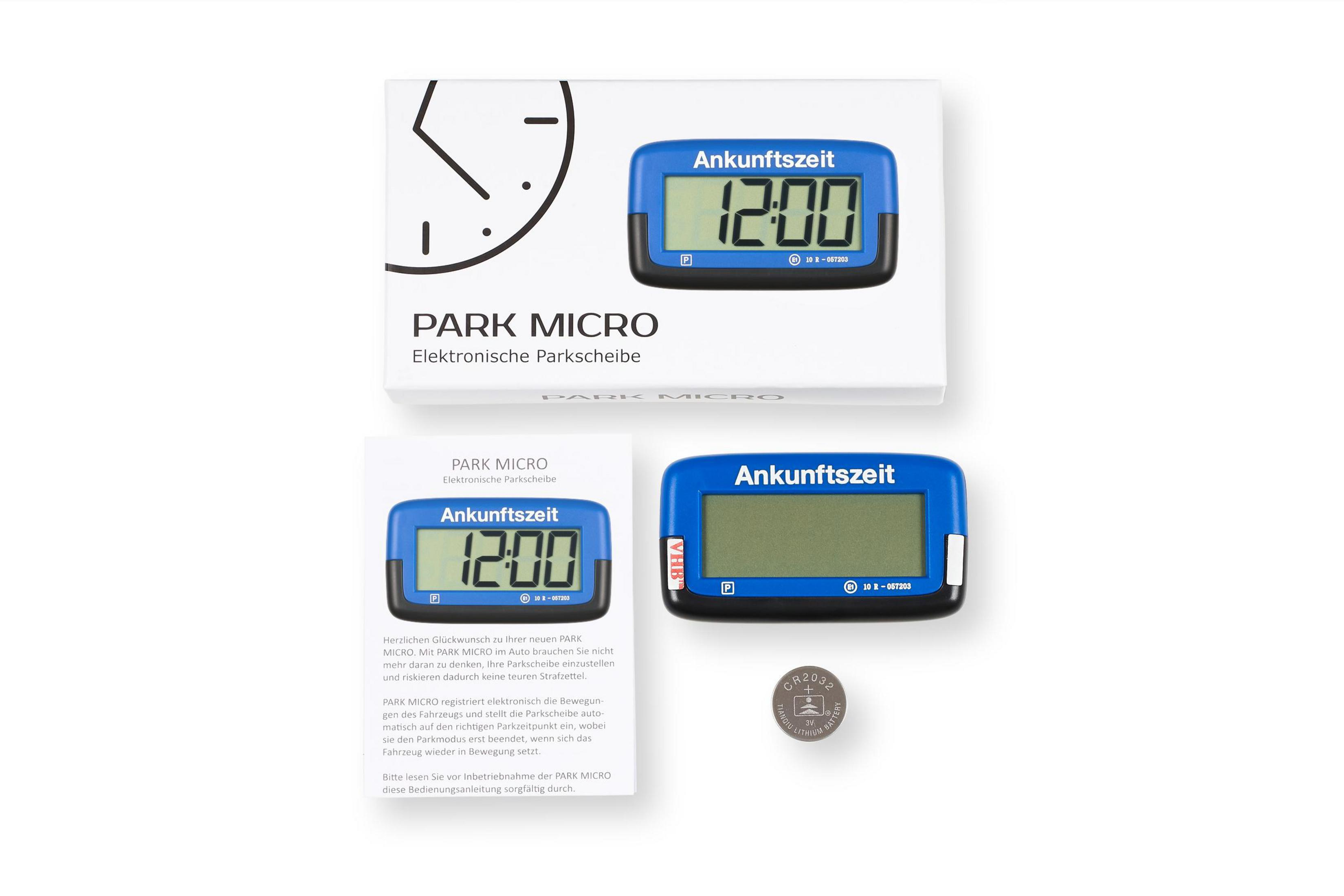 Ein Parkscheibenset mit der Scheibe, die 12:00 anzeigt, einer weißen Box, einer Anleitung und einer Batterie. Text ist Deutsch.