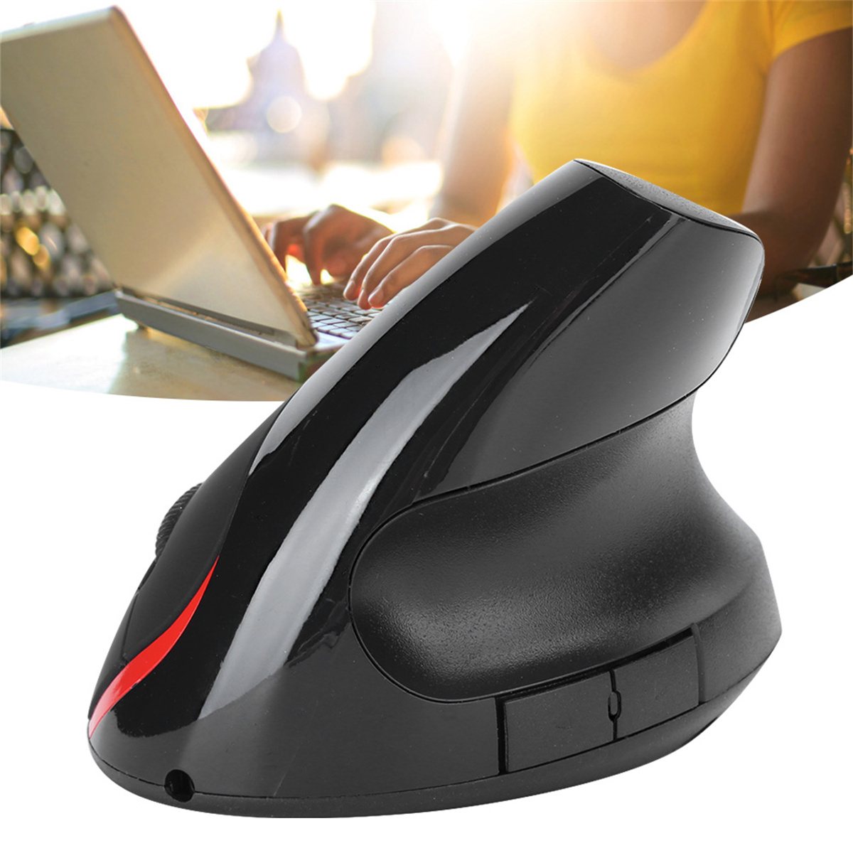 Eine schwarze ergonomische Maus mit rotem Streifen, in der Nähe eines Laptops.