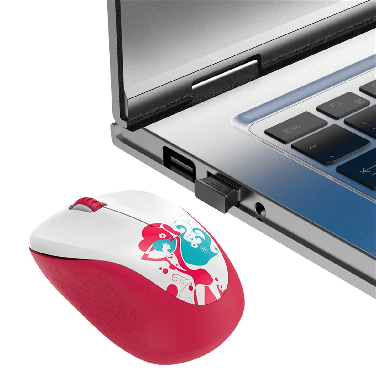 Eine rot-weiße Maus mit Cartoon-Design neben einem Laptop.