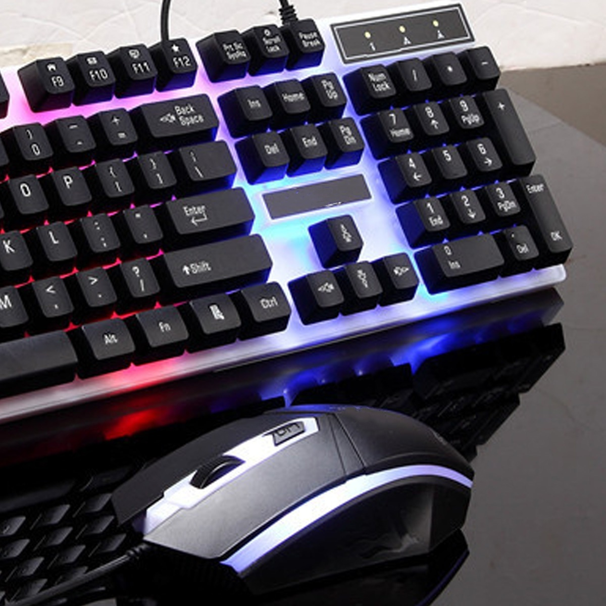 Schwarze Tastatur mit beleuchteten Tasten und eine schwarze Maus auf reflektierender Oberfläche.