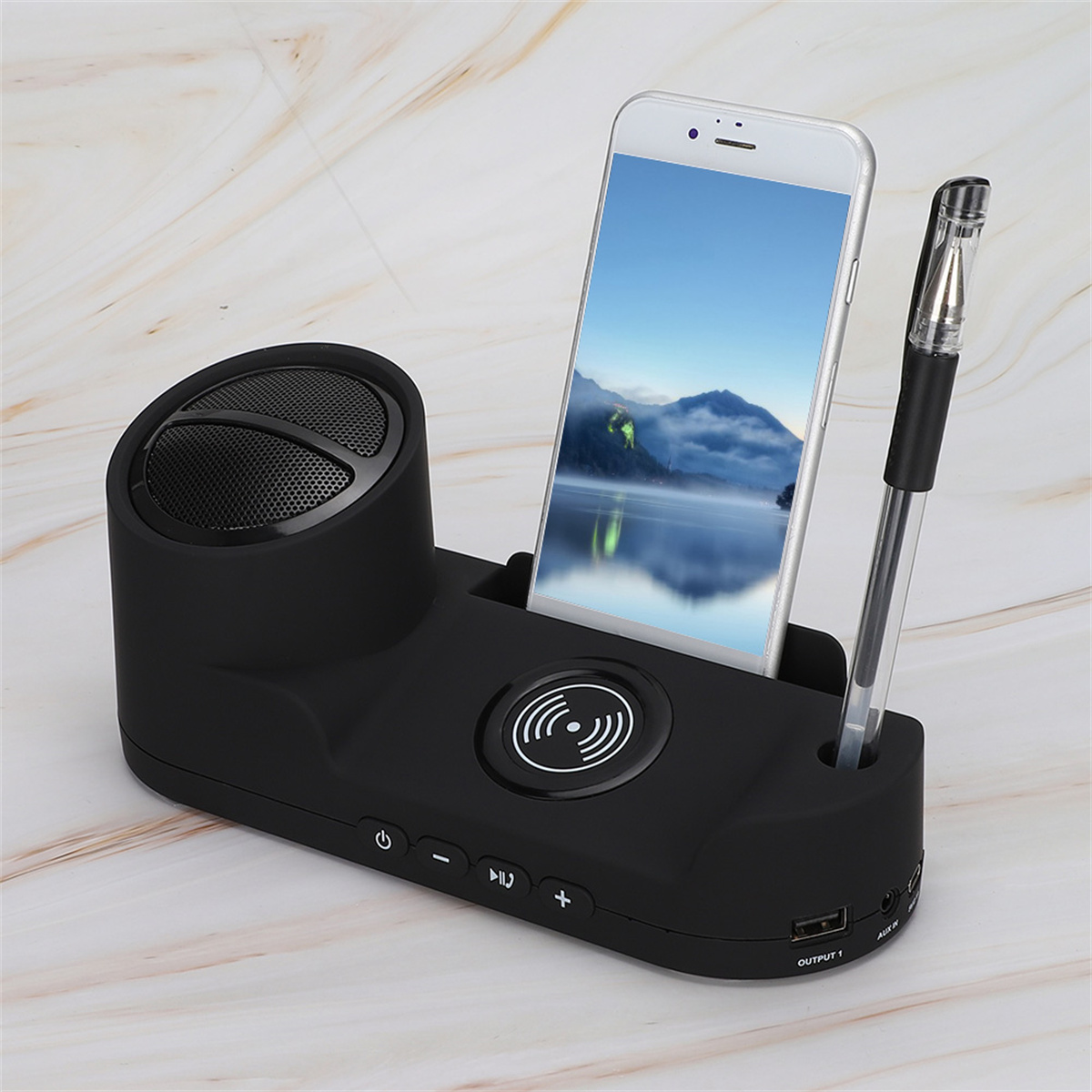 Schwarze Ladestation mit Telefon, Stift und Lautsprecher. Auf einer Marmoroberfläche.