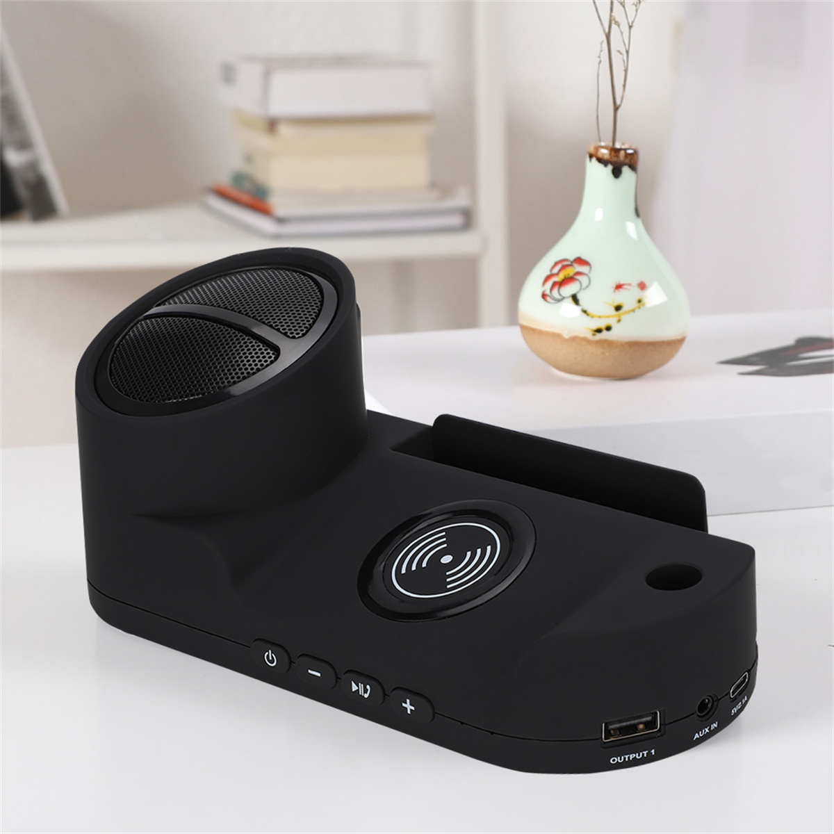 Schwarzer Lautsprecher/Ladegerät. Hat Lautsprecher, Tasten, USB-Anschluss und Pad.