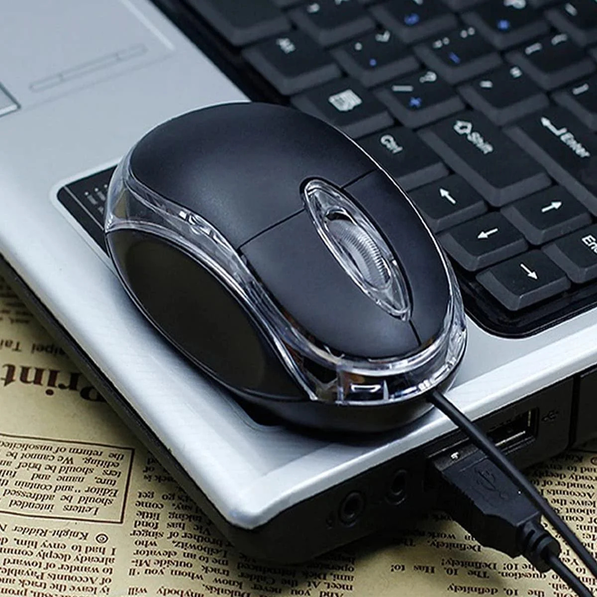 Schwarze Computermaus mit klarer Seite und USB-Kabel.