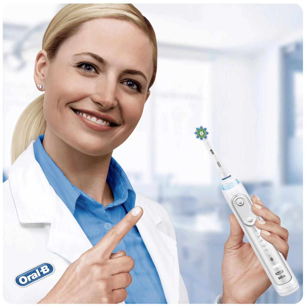 Frau hält eine elektrische Zahnbürste und zeigt darauf. Oral-B-Logo sichtbar.