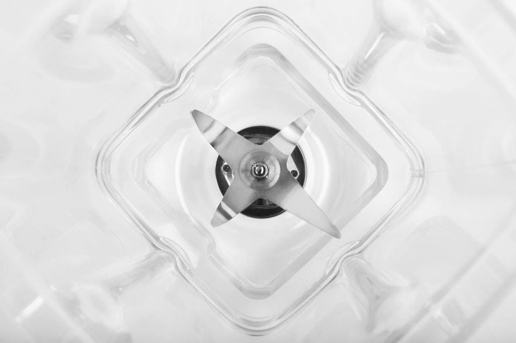 Podstawa blendera z ostrzem w kształcie gwiazdy wewnątrz przezroczystego pojemnika.