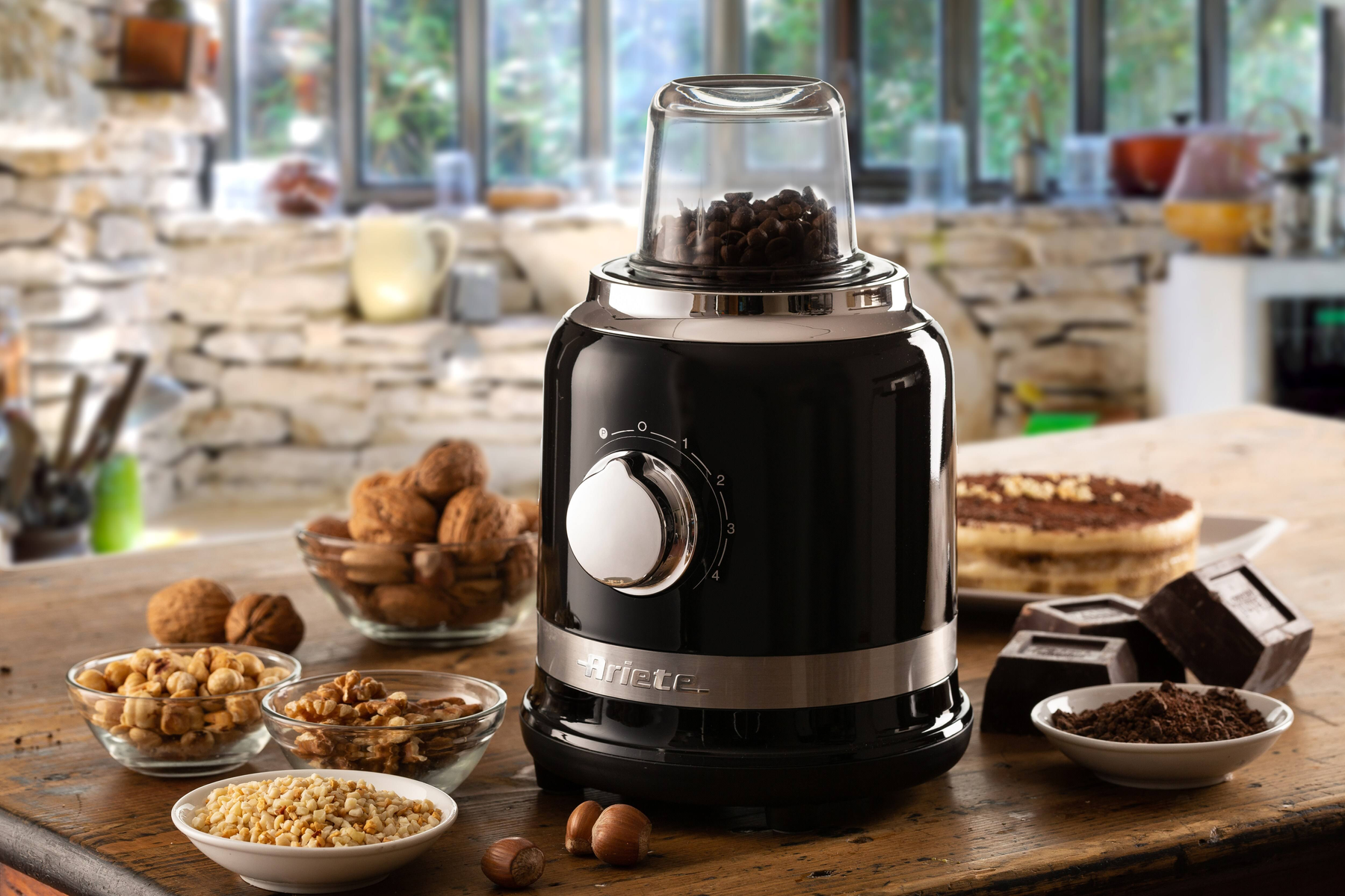 Macinacaffè nero con chicchi di caffè all'interno e ingredienti come noci e cioccolato.