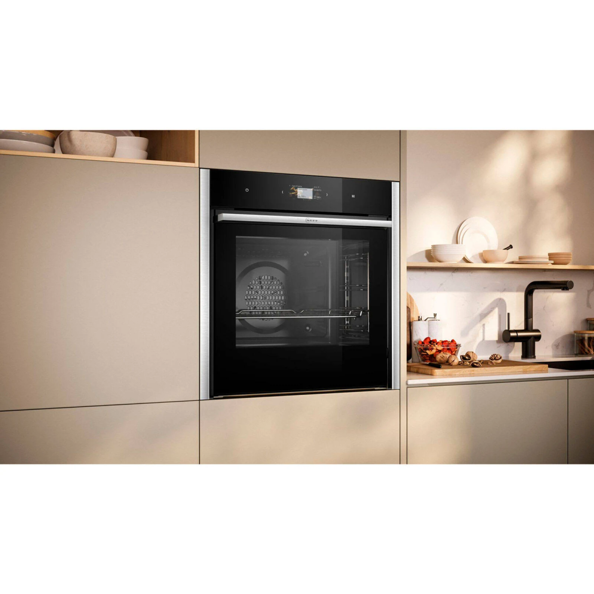 Forno integrato in una parete della cucina beige. È nero con una porta a vetri.
