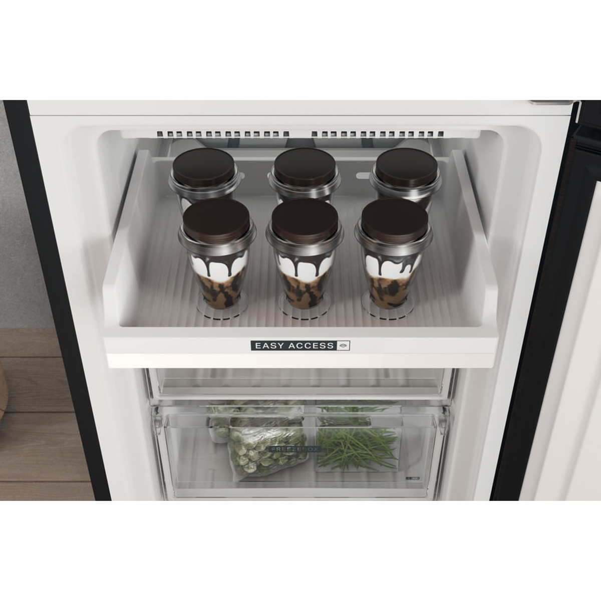 Sección congelador del refrigerador con dos cajones. Vasos de helado en el estante superior.