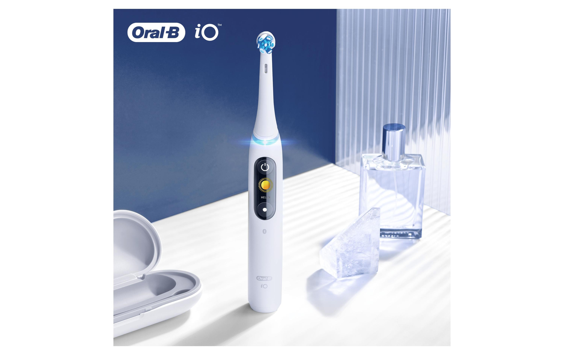 Cepillo de dientes eléctrico blanco con cerdas azules, un soporte de carga, un frasco de perfume de vidrio y un bloque de hielo.