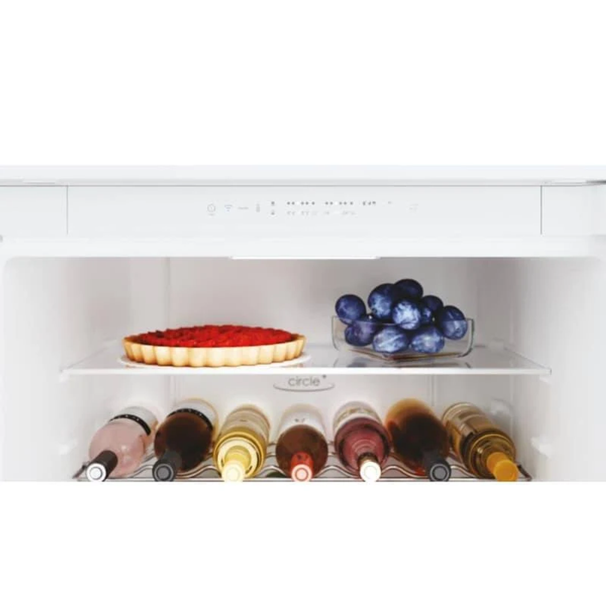 Otwarta lodówka z tartą, winogronami i butelkami wina na półkach, z przyciskami sterowania na górze.