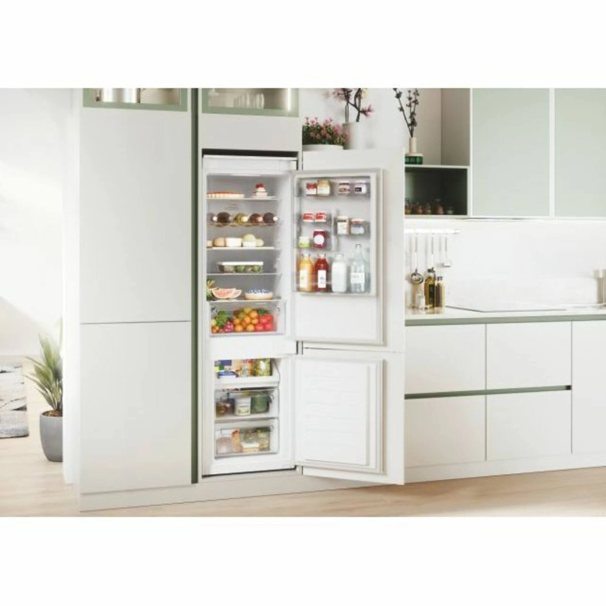 Cucina con un frigorifero bianco con la porta aperta, che mostra il cibo all'interno.