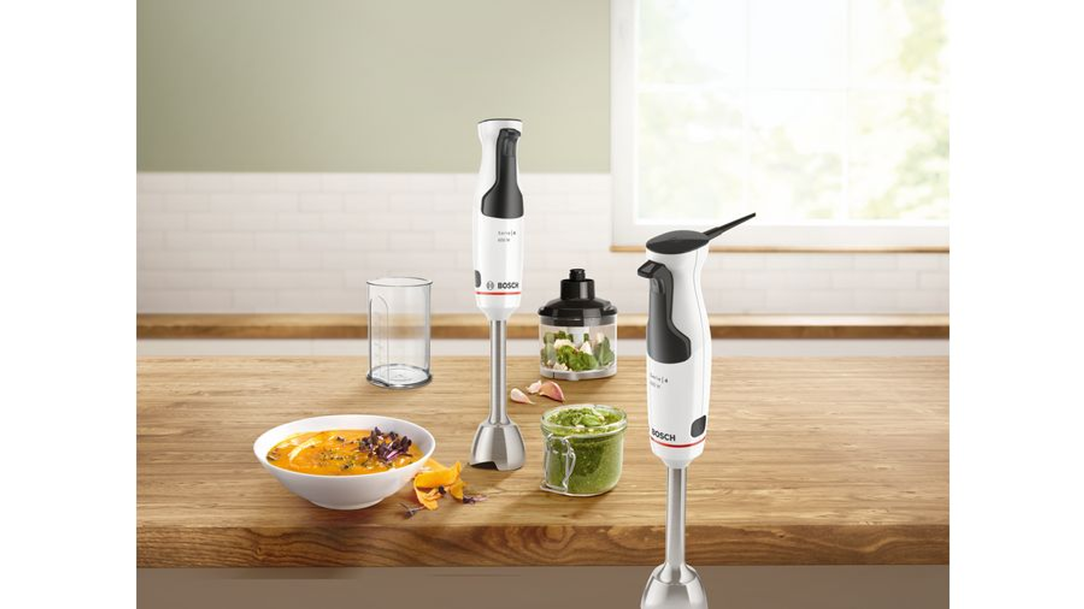 Blat kuchenny z blenderami, jedzeniem i składnikami. Dwa blendery i szklanka.